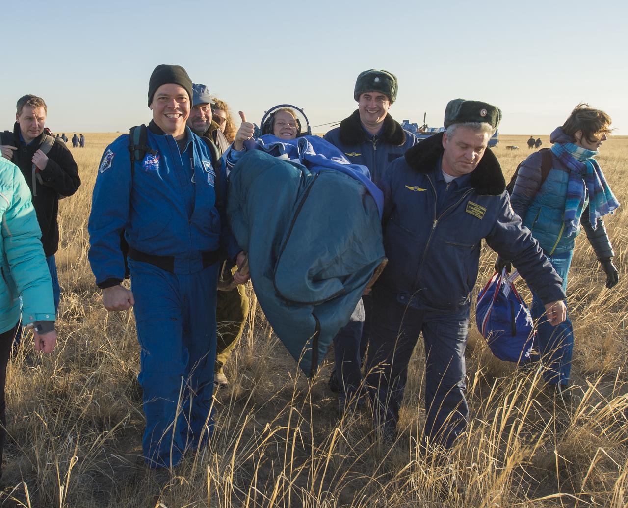 Expedition 37 NASA Flight Engineer Karen Nyberg gives the thumbs up as she is carried to the inflatable medical tent after her landing in the Soyuz TMA-09M spacecraft in a remote area southeast of the town of Zhezkazgan, Kazakhstan, on Monday, Nov. 11, 2013. Nyberg, Expedition 37 Commander Fyodor Yurchikhin of the Russian Federal Space Agency (Roscosmos) and Italian Flight Engineer Luca Parmitano returned to earth after five and a half months on the International Space Station. Photo Credit: (NASA/Carla Cioffi)
