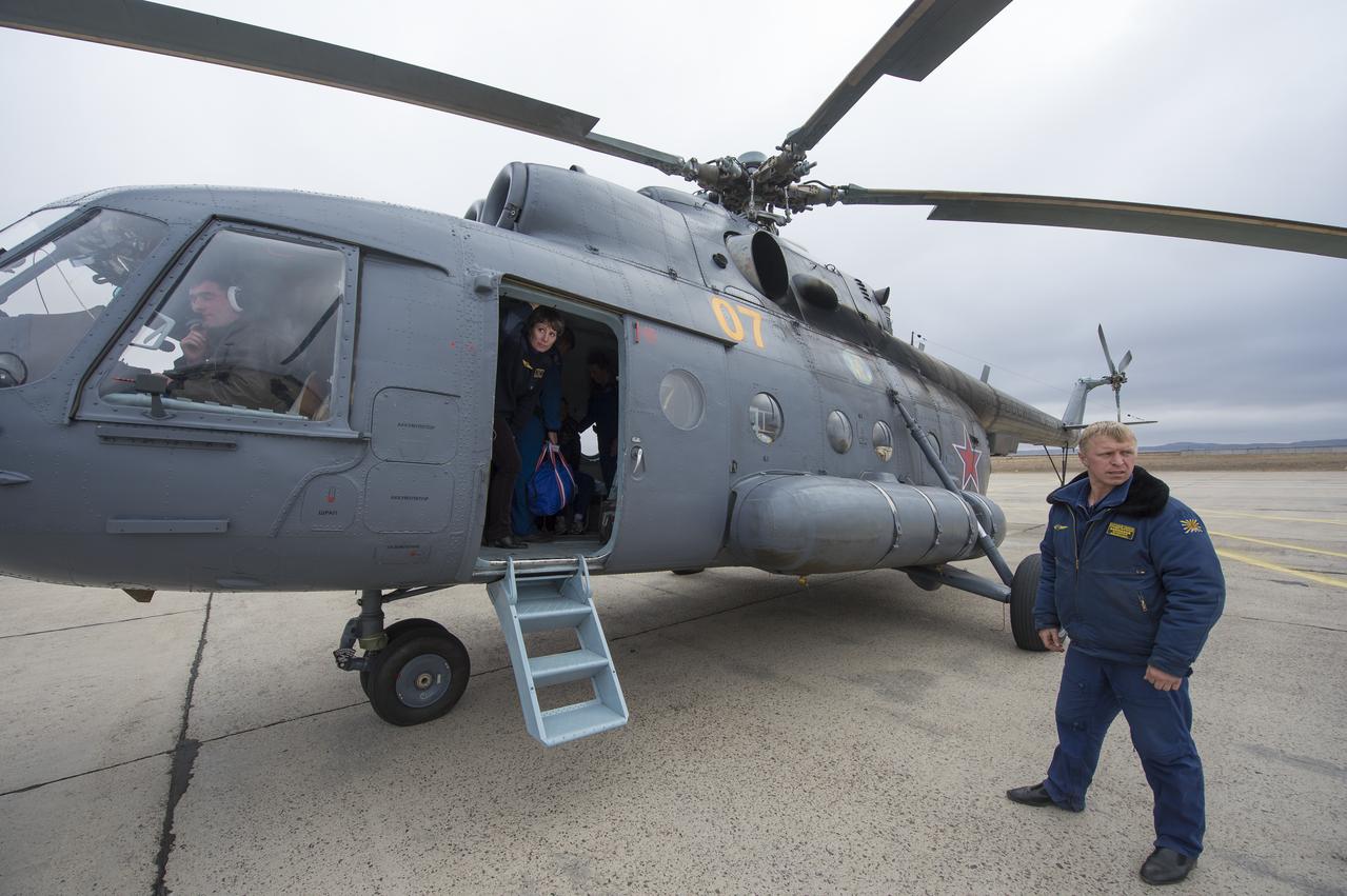 Russian Search and Rescue personnel prepare to assist Expedition 37 Flight Engineer Karen Nyberg from the helicopter shortly after her arrival at the Karaganda airport in Kazakhstan, Monday, Nov. 11, 2013.  Nyberg, Expedition 37 Commander Fyodor Yurchikhin of the Russian Federal Space Agency (Roscosmos) and Italian Flight Engineer Luca Parmitano landed in a remote area outside of the town of Zhezkazgan after after five and a half months spent on the International Space Station. Photo Credit: (NASA/Carla Cioffi)