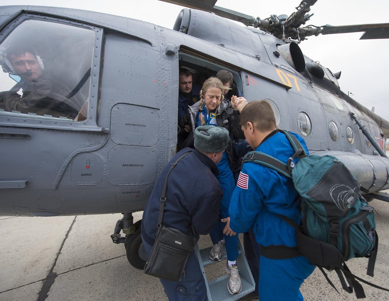 Expedition 37 NASA Flight Engineer Karen Nyberg is helped off the helicopter upon her arrival in Karaganda, Kazakhstan after her landing in the Soyuz TMA-09M spacecraft in a remote area southeast of the town of Zhezkazgan, Monday, Nov. 11, 2013.  Nyberg, Expedition 37 Commander Fyodor Yurchikhin of the Russian Federal Space Agency (Roscosmos) and Italian Flight Engineer Luca Parmitano returned to earth after five and a half months on the International Space Station. Photo Credit: (NASA/Carla Cioffi)