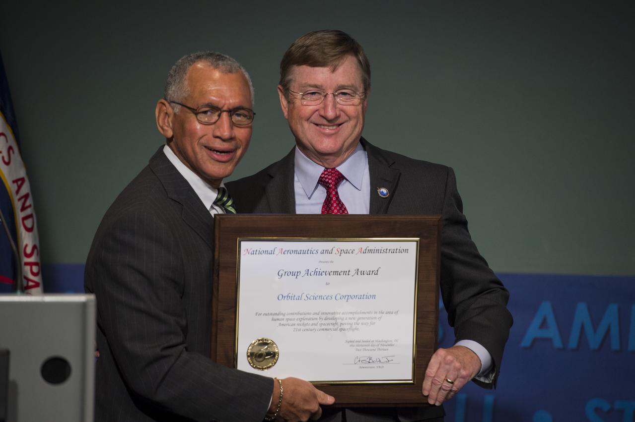 NASA Administrator Charles Bolden, left, presents NASA's Group Achievement Award to (L-R) Frank Culbertson, Executive Vice President and General Manager, Orbital Sciences Advanced Programs Group,at NASA Headquarters in Washington on Thursday, November 13, 2013. Culbertson received the award for outstanding contributions and innovative accomplishments in the completion of the Commercial Orbital Transportation Services (COTS) initiative. Through COTS, NASA's partners Space Exploration Technologies Corp. (SpaceX) and Orbital Sciences Corp., developed new U.S. rockets and spacecraft, launched from U.S. soil, capable of transporting cargo to low-Earth orbit and the International Space Station. Photo Credit: (NASA/Jay Westcott)