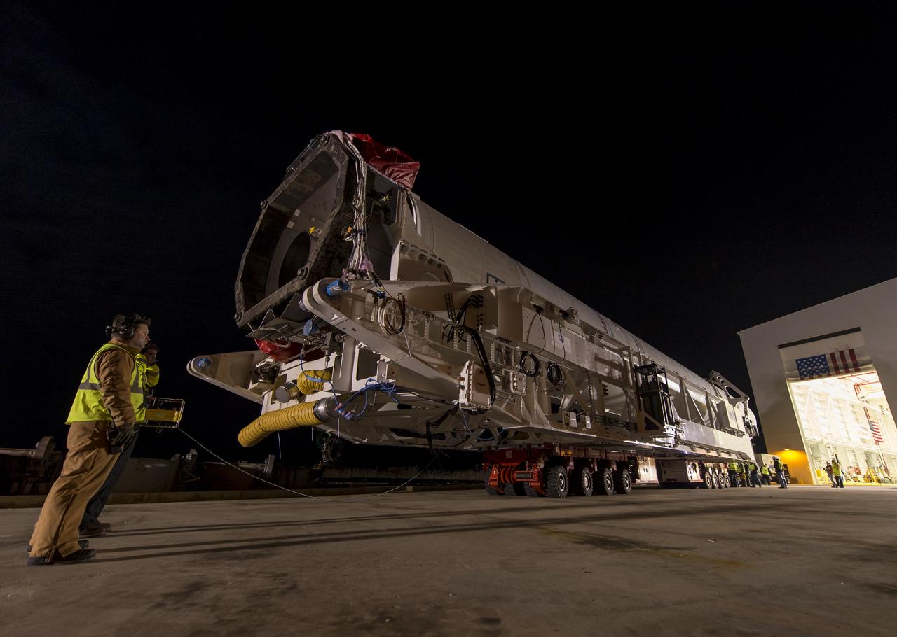 An Orbital Science Corporation Antares rocket is seen as it is rolled out to launch Pad-0A at NASA's Wallops Flight Facility Tuesday, December 17, 2013 in advance of a Thursday launch, Wallops Island, VA. The Antares will launch a Cygnus spacecraft on a cargo resupply mission to the International Space Station. The Orbital-1 mission is Orbital Sciences' first contracted cargo delivery flight to the space station for NASA. Among the cargo aboard Cygnus set to launch to the space station are science experiments, crew provisions, spare parts and other hardware. Launch is scheduled for 9:19 p.m. EST on Thursday, Dec. 19. Weather permitting, it may be widely visible along the east coast of the United States. Photo Credit: (NASA/Bill Ingalls)