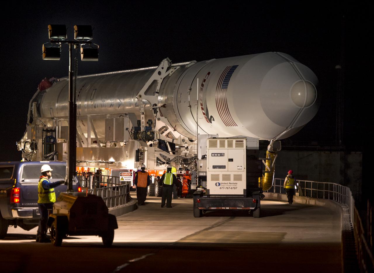 An Orbital Science Corporation Antares rocket is seen as it is rolled out to launch Pad-0A at NASA's Wallops Flight Facility Tuesday, December 17, 2013 in advance of a Thursday launch, Wallops Island, VA. The Antares will launch a Cygnus spacecraft on a cargo resupply mission to the International Space Station. The Orbital-1 mission is Orbital Sciences' first contracted cargo delivery flight to the space station for NASA. Among the cargo aboard Cygnus set to launch to the space station are science experiments, crew provisions, spare parts and other hardware. Launch is scheduled for 9:19 p.m. EST on Thursday, Dec. 19. Weather permitting, it may be widely visible along the east coast of the United States. Photo Credit: (NASA/Bill Ingalls)