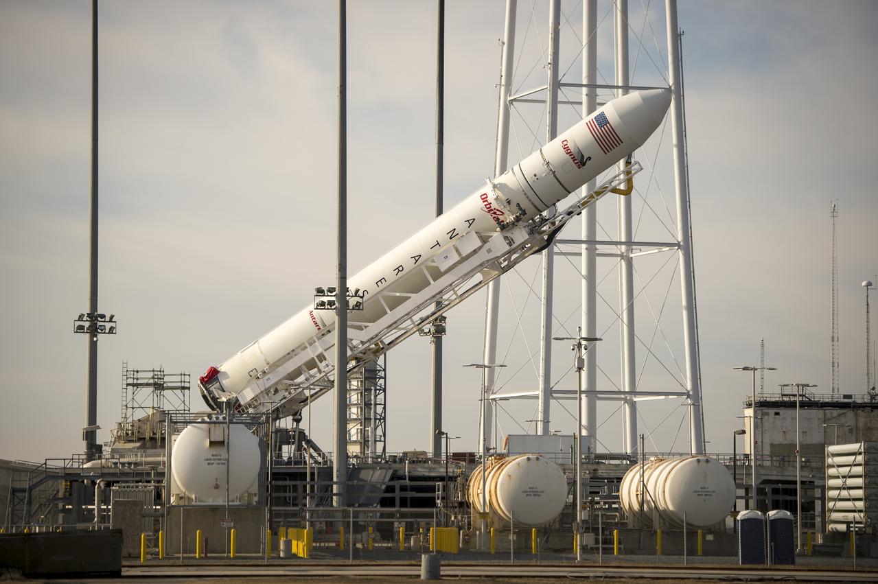 The Orbital Science Corporation Antares rocket is seen as it is raised into position at launch Pad-0A, Tuesday, December 17, 2013, at NASA's Wallops Flight Facility, Wallops Island, VA. The Antares will launch a Cygnus spacecraft on a cargo resupply mission to the International Space Station. The Orbital-1 mission is Orbital Sciences' first contracted cargo delivery flight to the space station for NASA. Among the cargo aboard Cygnus set to launch to the space station are science experiments, crew provisions, spare parts and other hardware. Launch is scheduled for 9:19 p.m. EST on Thursday, Dec. 19. Weather permitting, it may be widely visible along the east coast of the United States. Photo Credit: (NASA/Bill Ingalls)