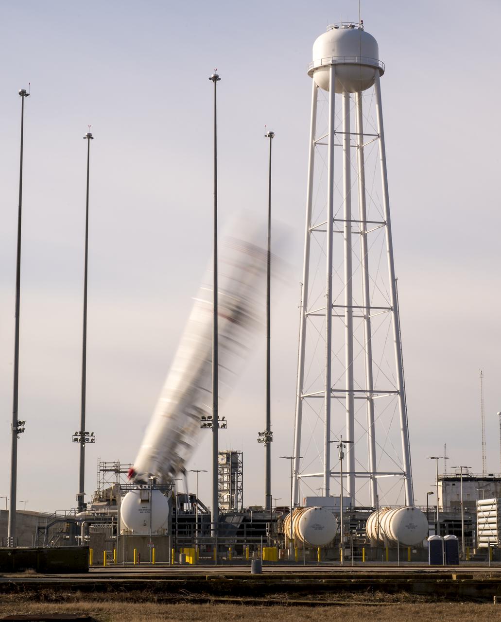 The Orbital Science Corporation Antares rocket is seen in this four minute exposure as it is raised into position at launch Pad-0A, Tuesday, December 17, 2013, at NASA's Wallops Flight Facility, Wallops Island, VA. The Antares will launch a Cygnus spacecraft on a cargo resupply mission to the International Space Station. The Orbital-1 mission is Orbital Sciences' first contracted cargo delivery flight to the space station for NASA. Among the cargo aboard Cygnus set to launch to the space station are science experiments, crew provisions, spare parts and other hardware. Launch is scheduled for 9:19 p.m. EST on Thursday, Dec. 19. Weather permitting, it may be widely visible along the east coast of the United States. Photo Credit: (NASA/Bill Ingalls)