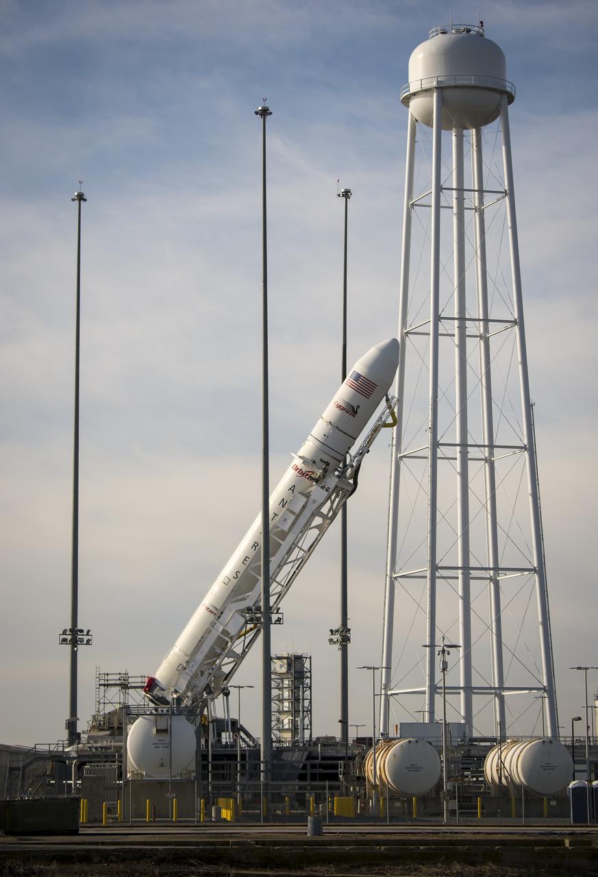 The Orbital Science Corporation Antares rocket is seen as it is raised into position at launch Pad-0A, Tuesday, December 17, 2013, at NASA's Wallops Flight Facility, Wallops Island, VA. The Antares will launch a Cygnus spacecraft on a cargo resupply mission to the International Space Station. The Orbital-1 mission is Orbital Sciences' first contracted cargo delivery flight to the space station for NASA. Among the cargo aboard Cygnus set to launch to the space station are science experiments, crew provisions, spare parts and other hardware. Launch is scheduled for 9:19 p.m. EST on Thursday, Dec. 19. Weather permitting, it may be widely visible along the east coast of the United States. Photo Credit: (NASA/Bill Ingalls)