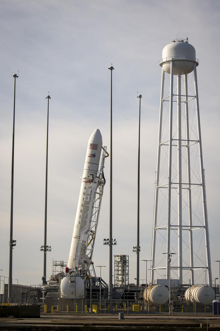 The Orbital Science Corporation Antares rocket is seen as it is raised into position at launch Pad-0A, Tuesday, December 17, 2013, at NASA's Wallops Flight Facility, Wallops Island, VA. The Antares will launch a Cygnus spacecraft on a cargo resupply mission to the International Space Station. The Orbital-1 mission is Orbital Sciences' first contracted cargo delivery flight to the space station for NASA. Among the cargo aboard Cygnus set to launch to the space station are science experiments, crew provisions, spare parts and other hardware. Launch is scheduled for 9:19 p.m. EST on Thursday, Dec. 19. Weather permitting, it may be widely visible along the east coast of the United States. Photo Credit: (NASA/Bill Ingalls)