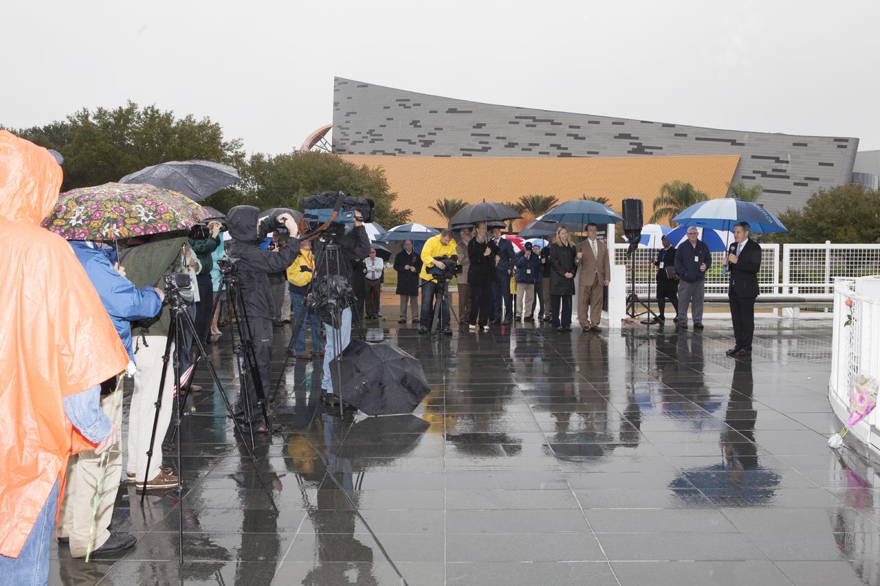 CAPE CANAVERAL, Fla. -- Under rainy skies, Kennedy Space Center Director Bob Cabana speaks to guests after placing a wreath in front of the Space Mirror Memorial at the spaceport's Visitor Complex during NASA's Day of Remembrance. The brief ceremony honored the astronauts of Apollo 1, who were lost in 1967, the shuttle Challenger crew, who perished in 1986, the space shuttle Columbia astronauts who were lost in 2003, as well as other astronauts who gave their lives while furthering the cause of exploration and discovery.  Dedicated in 1991, the names of fallen astronauts are emblazoned the monument's 4.5-foot-high-by-50-foot-wide polished black granite surface which reflects the sky and has been designated by Congress as a National Memorial. Photo credit: NASA_Dimitri Gerondidakis