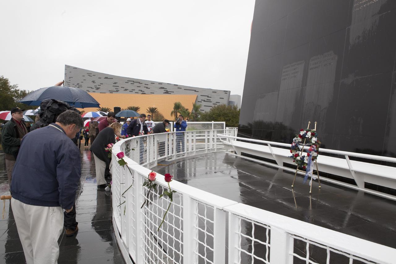 CAPE CANAVERAL, Fla. -- Kennedy Space Center Employees and guests placed flowers at the Space Mirror Memorial at the spaceport's Visitor Complex during NASA's Day of Remembrance. A brief ceremony honored the astronauts of Apollo 1, who were lost in 1967, the shuttle Challenger crew, who perished in 1986, the space shuttle Columbia astronauts who were lost in 2003, as well as other astronauts who gave their lives while furthering the cause of exploration and discovery.    Dedicated in 1991, the names of fallen astronauts are emblazoned the monument's 4.5-foot-high-by-50-foot-wide polished black granite surface which reflects the sky and has been designated by Congress as a National Memorial. Photo credit: NASA/Dimitri Gerondidakis