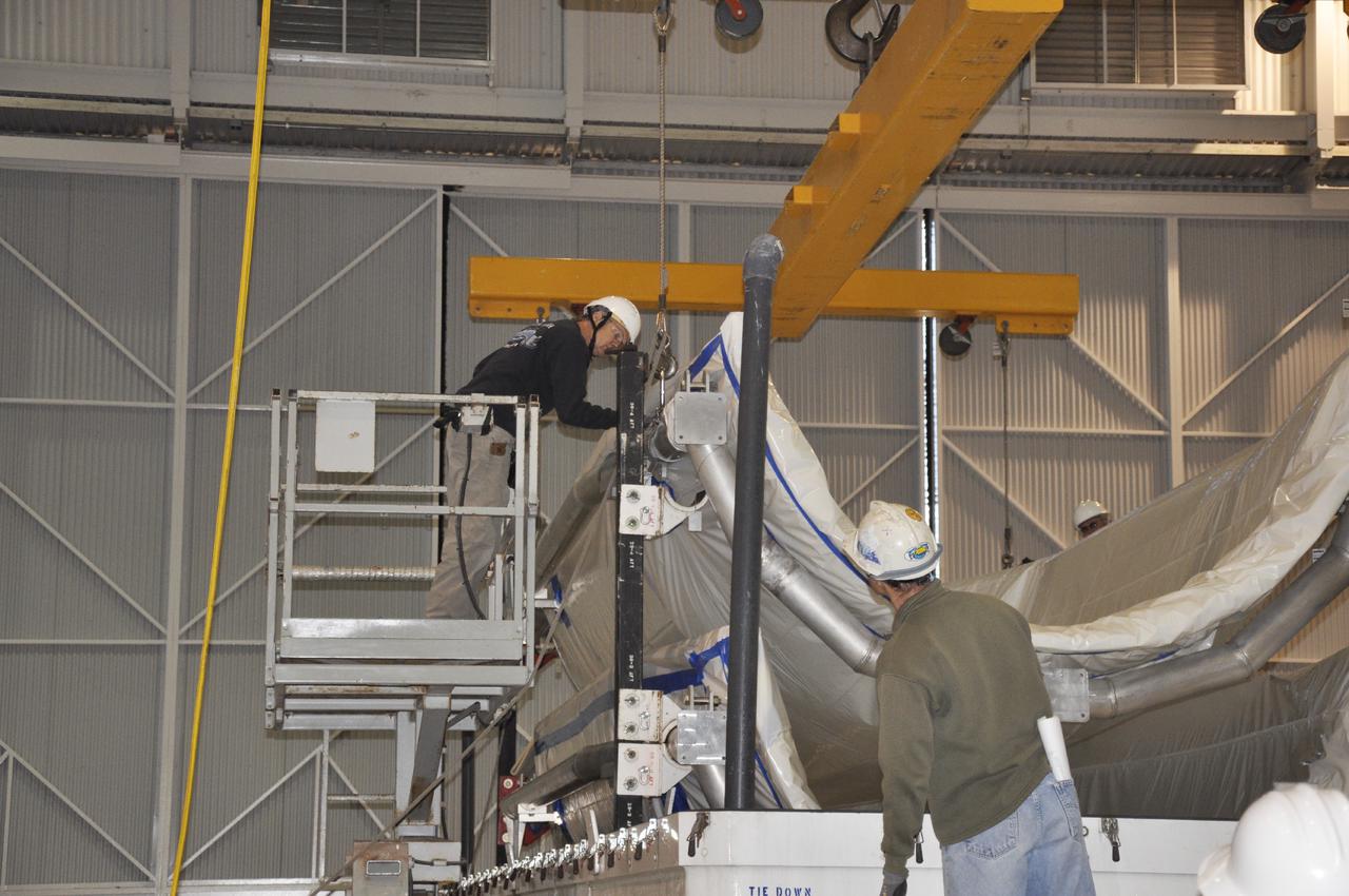 VANDENBERG AIR FORCE BASE, Calif. – Workers prepare to remove sections of the fairing for NASA's Orbiting Carbon Observatory-2 mission, or OCO-2, from its shipping container in the NASA Building 836 high bay at Vandenberg Air Force Base in California.    The fairing will protect OCO-2 during launch aboard a United Launch Alliance Delta II rocket from Space Launch Complex 2 in July. OCO-2 will collect precise global measurements of carbon dioxide in the Earth's atmosphere and provide scientists with a better idea of the chemical compound's impacts on climate change. Scientists will analyze this data to improve our understanding of the natural processes and human activities that regulate the abundance and distribution of this important atmospheric gas. To learn more about OCO-2, visit http:__oco.jpl.nasa.gov.  Photo credit: NASA_Randy Beaudoin