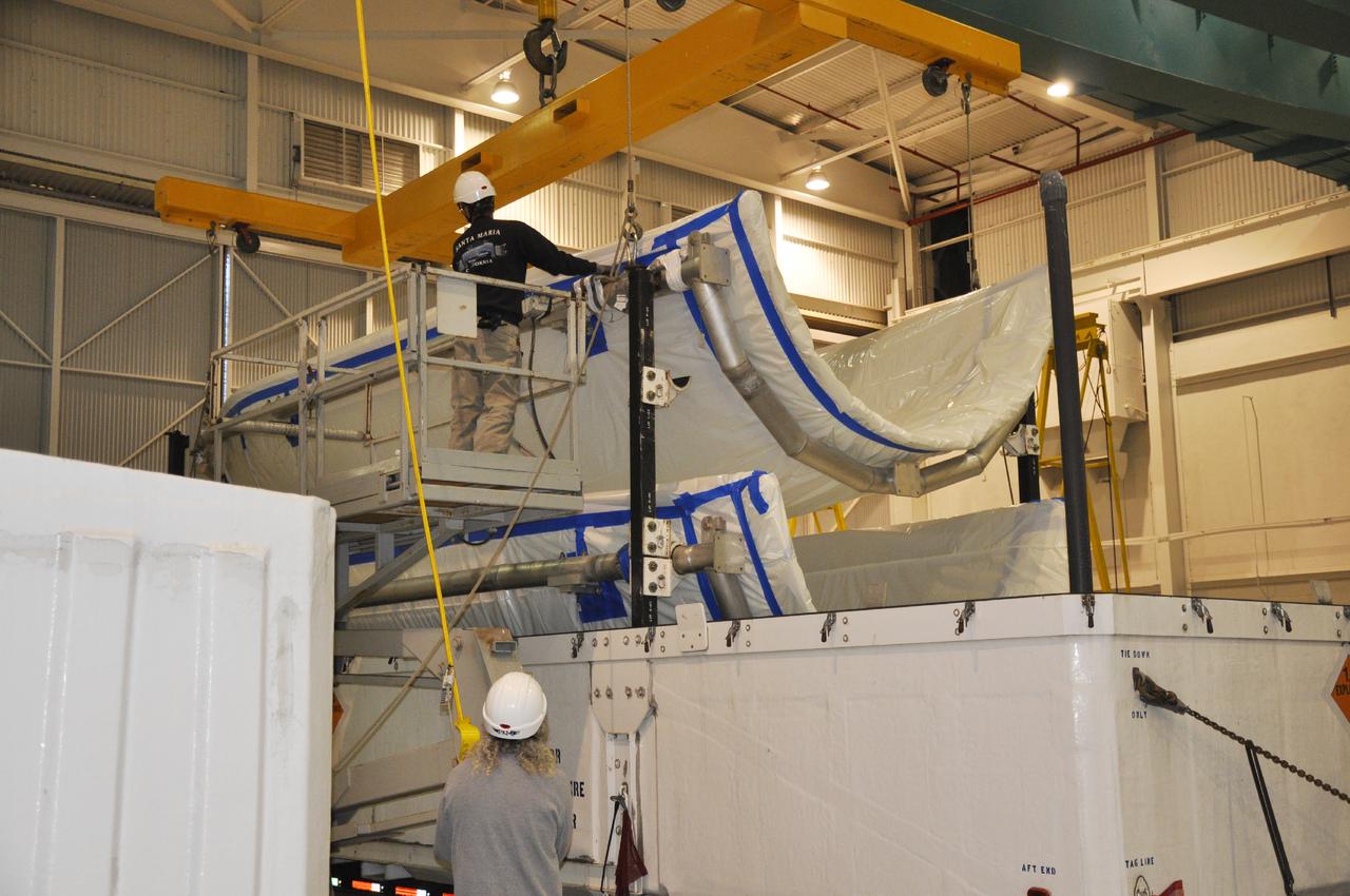 VANDENBERG AIR FORCE BASE, Calif. – Workers prepare to hoist sections of the fairing for NASA's Orbiting Carbon Observatory-2 mission, or OCO-2, from its shipping container in the NASA Building 836 high bay at Vandenberg Air Force Base in California.    The fairing will protect OCO-2 during launch aboard a United Launch Alliance Delta II rocket from Space Launch Complex 2 in July. OCO-2 will collect precise global measurements of carbon dioxide in the Earth's atmosphere and provide scientists with a better idea of the chemical compound's impacts on climate change. Scientists will analyze this data to improve our understanding of the natural processes and human activities that regulate the abundance and distribution of this important atmospheric gas. To learn more about OCO-2, visit http:__oco.jpl.nasa.gov.  Photo credit: NASA_Randy Beaudoin