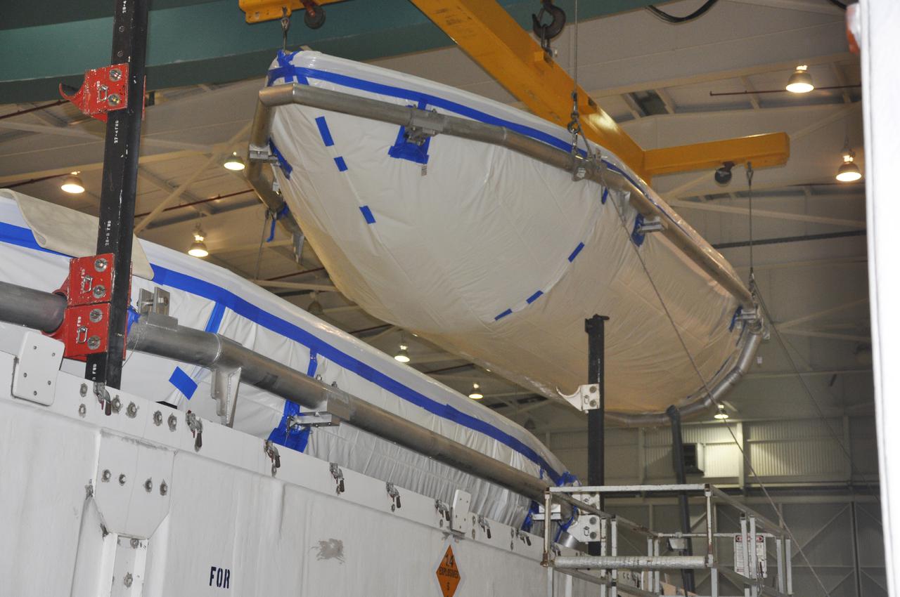 VANDENBERG AIR FORCE BASE, Calif. – In the NASA Building 836 high bay at Vandenberg Air Force Base in California, workers hoist a section of the fairing for NASA's Orbiting Carbon Observatory-2 mission, or OCO-2, from its shipping container.    The fairing will protect OCO-2 during launch aboard a United Launch Alliance Delta II rocket from Space Launch Complex 2 in July. OCO-2 will collect precise global measurements of carbon dioxide in the Earth's atmosphere and provide scientists with a better idea of the chemical compound's impacts on climate change. Scientists will analyze this data to improve our understanding of the natural processes and human activities that regulate the abundance and distribution of this important atmospheric gas. To learn more about OCO-2, visit http:__oco.jpl.nasa.gov.  Photo credit: NASA_Randy Beaudoin