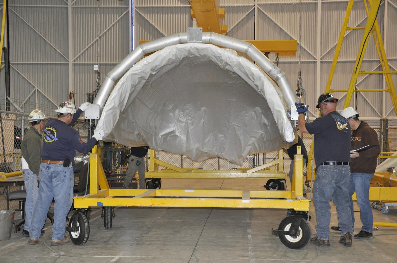 VANDENBERG AIR FORCE BASE, Calif. – In the NASA Building 836 high bay at Vandenberg Air Force Base in California, workers position a section of the fairing for NASA's Orbiting Carbon Observatory-2 mission, or OCO-2, onto a mobile fairing trailer.      The fairing will protect OCO-2 during launch aboard a United Launch Alliance Delta II rocket from Space Launch Complex 2 in July. OCO-2 will collect precise global measurements of carbon dioxide in the Earth's atmosphere and provide scientists with a better idea of the chemical compound's impacts on climate change. Scientists will analyze this data to improve our understanding of the natural processes and human activities that regulate the abundance and distribution of this important atmospheric gas. To learn more about OCO-2, visit http:__oco.jpl.nasa.gov.  Photo credit: NASA_Randy Beaudoin