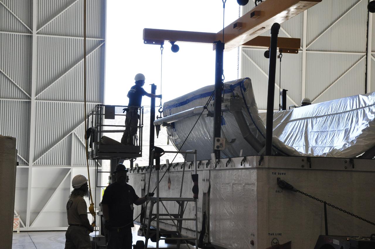 VANDENBERG AIR FORCE BASE, Calif. – In the NASA Building 836 high bay at Vandenberg Air Force Base in California, workers lift a section of the fairing for NASA's Orbiting Carbon Observatory-2 mission, or OCO-2, from its shipping container.      The fairing will protect OCO-2 during launch aboard a United Launch Alliance Delta II rocket from Space Launch Complex 2 in July. OCO-2 will collect precise global measurements of carbon dioxide in the Earth's atmosphere and provide scientists with a better idea of the chemical compound's impacts on climate change. Scientists will analyze this data to improve our understanding of the natural processes and human activities that regulate the abundance and distribution of this important atmospheric gas. To learn more about OCO-2, visit http:__oco.jpl.nasa.gov.  Photo credit: NASA_Randy Beaudoin
