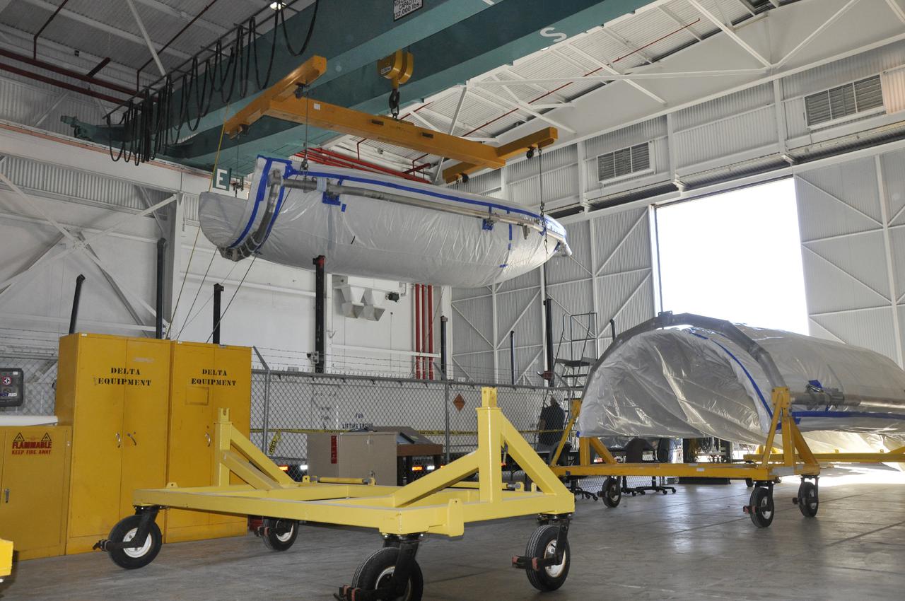VANDENBERG AIR FORCE BASE, Calif. – A section of the fairing for NASA's Orbiting Carbon Observatory-2 mission, or OCO-2, is lifted from its shipping container in the NASA Building 836 high bay at Vandenberg Air Force Base in California.      The fairing will protect OCO-2 during launch aboard a United Launch Alliance Delta II rocket from Space Launch Complex 2 in July. OCO-2 will collect precise global measurements of carbon dioxide in the Earth's atmosphere and provide scientists with a better idea of the chemical compound's impacts on climate change. Scientists will analyze this data to improve our understanding of the natural processes and human activities that regulate the abundance and distribution of this important atmospheric gas. To learn more about OCO-2, visit http:__oco.jpl.nasa.gov.  Photo credit: NASA_Randy Beaudoin