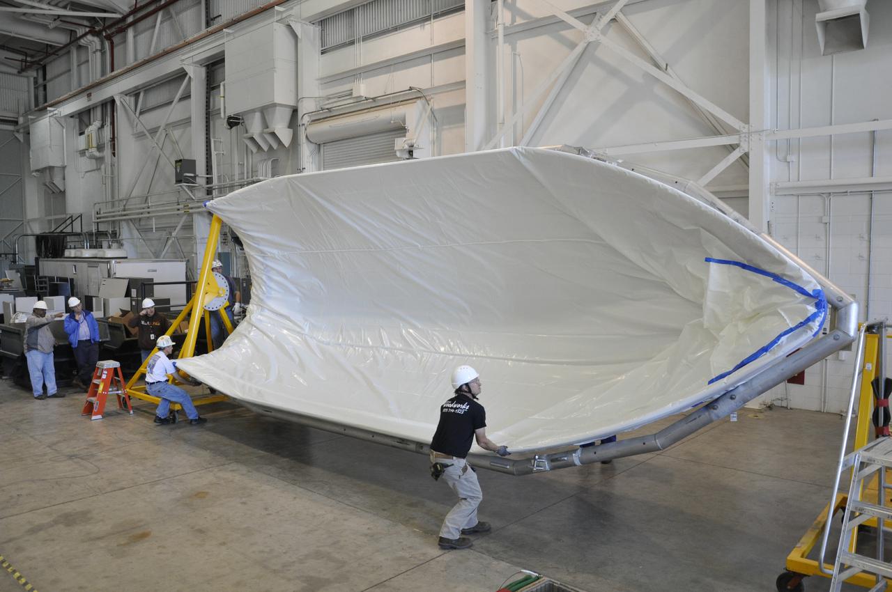 VANDENBERG AIR FORCE BASE, Calif. – In the NASA Building 836 high bay at Vandenberg Air Force Base in California, workers rotate a section of the fairing for NASA's Orbiting Carbon Observatory-2 mission, or OCO-2, following its removal from its shipping container.      The fairing will protect OCO-2 during launch aboard a United Launch Alliance Delta II rocket from Space Launch Complex 2 in July. OCO-2 will collect precise global measurements of carbon dioxide in the Earth's atmosphere and provide scientists with a better idea of the chemical compound's impacts on climate change. Scientists will analyze this data to improve our understanding of the natural processes and human activities that regulate the abundance and distribution of this important atmospheric gas. To learn more about OCO-2, visit http:__oco.jpl.nasa.gov.  Photo credit: NASA_Randy Beaudoin