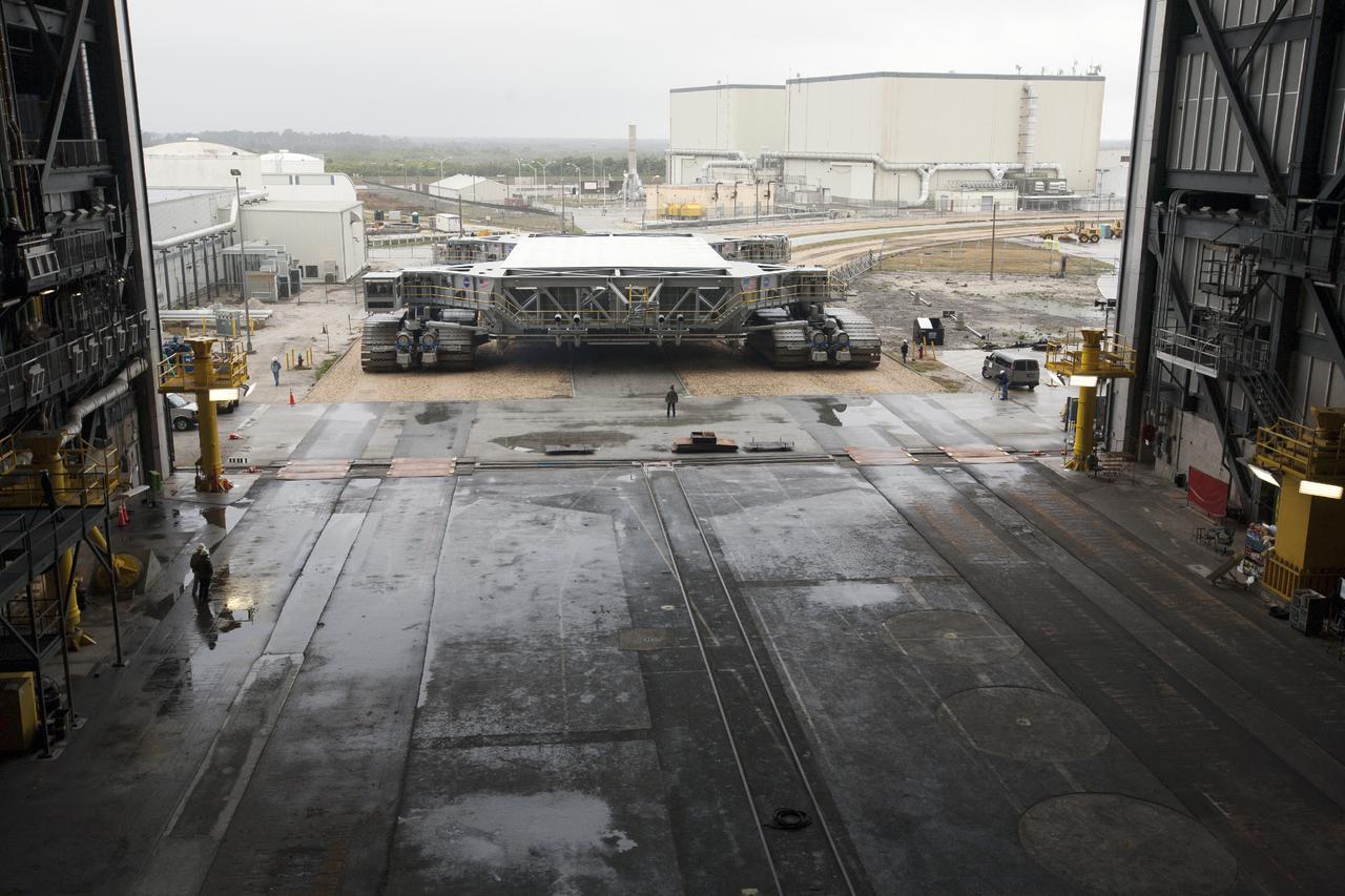 CAPE CANAVERAL, Fla. – Crawler-transporter 2, or CT-2, nears the entrance to the Vehicle Assembly Building at NASA’s Kennedy Space Center in Florida. The Ground Systems Development and Operations Program completed a roller bearing assembly test on CT-2 truck sections A and C. The left- and right-hand steering was tested in both directions. The temperature of the roller assemblies was monitored and recorded as it traveled along the crawlerway. Engineers and technicians performed visual inspections of the roller bearing pumps, valves and lines to ensure that the grease injectors worked properly and provided the required flow of grease to the new roller assemblies.  Work continues in high bay 2 to upgrade CT-2. The modifications are designed to ensure CT-2’s ability to transport launch vehicles currently in development, such as the agency’s Space Launch System, to the launch pad. The Ground Systems Development and Operations Program office at Kennedy is overseeing the upgrades. For more than 45 years the crawler-transporters were used to transport the mobile launcher platform and the Apollo-Saturn V rockets and, later, space shuttles to Launch Pads 39A and B. For more information, visit: http:__www.nasa.gov_exploration_systems_ground_crawler-transporter. Photo credit: NASA_Kim Shiflett