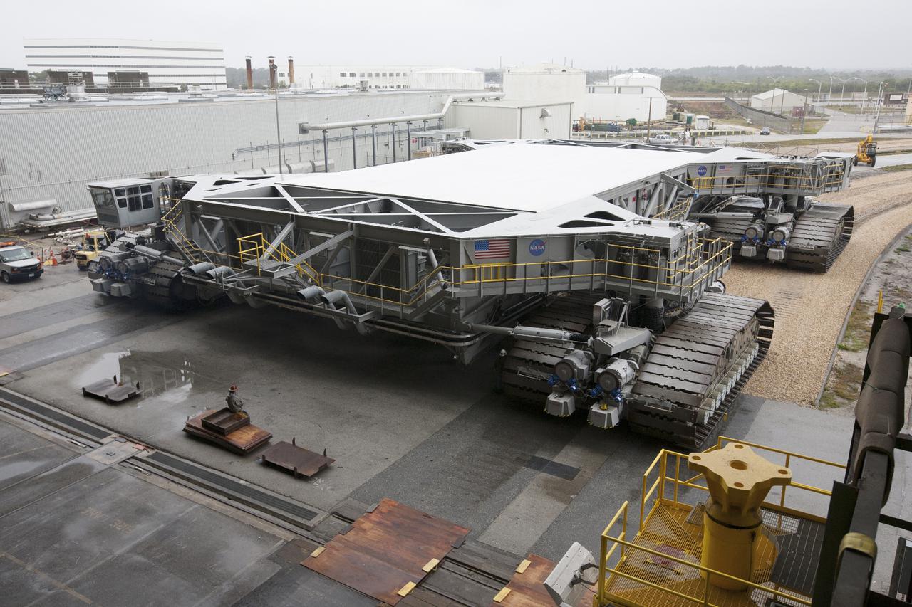 CAPE CANAVERAL, Fla. – Crawler-transporter 2, or CT-2, nears the entrance to the Vehicle Assembly Building at NASA’s Kennedy Space Center in Florida. The Ground Systems Development and Operations Program completed a roller bearing assembly test on CT-2 truck sections A and C. The left- and right-hand steering was tested in both directions. The temperature of the roller assemblies was monitored and recorded as it traveled along the crawlerway. Engineers and technicians performed visual inspections of the roller bearing pumps, valves and lines to ensure that the grease injectors worked properly and provided the required flow of grease to the new roller assemblies.  Work continues in high bay 2 to upgrade CT-2. The modifications are designed to ensure CT-2’s ability to transport launch vehicles currently in development, such as the agency’s Space Launch System, to the launch pad. The Ground Systems Development and Operations Program office at Kennedy is overseeing the upgrades. For more than 45 years the crawler-transporters were used to transport the mobile launcher platform and the Apollo-Saturn V rockets and, later, space shuttles to Launch Pads 39A and B. For more information, visit: http:__www.nasa.gov_exploration_systems_ground_crawler-transporter. Photo credit: NASA_Kim Shiflett