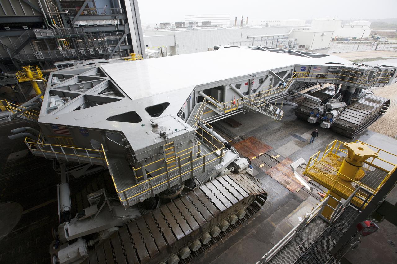 CAPE CANAVERAL, Fla. – Crawler-transporter 2, or CT-2, slowly enters the Vehicle Assembly Building at NASA’s Kennedy Space Center in Florida. The Ground Systems Development and Operations Program completed a roller bearing assembly test on CT-2 truck sections A and C. The left- and right-hand steering was tested in both directions. The temperature of the roller assemblies was monitored and recorded as it traveled along the crawlerway. Engineers and technicians performed visual inspections of the roller bearing pumps, valves and lines to ensure that the grease injectors worked properly and provided the required flow of grease to the new roller assemblies.  Work continues in high bay 2 to upgrade CT-2. The modifications are designed to ensure CT-2’s ability to transport launch vehicles currently in development, such as the agency’s Space Launch System, to the launch pad. The Ground Systems Development and Operations Program office at Kennedy is overseeing the upgrades. For more than 45 years the crawler-transporters were used to transport the mobile launcher platform and the Apollo-Saturn V rockets and, later, space shuttles to Launch Pads 39A and B. For more information, visit: http:__www.nasa.gov_exploration_systems_ground_crawler-transporter. Photo credit: NASA_Kim Shiflett