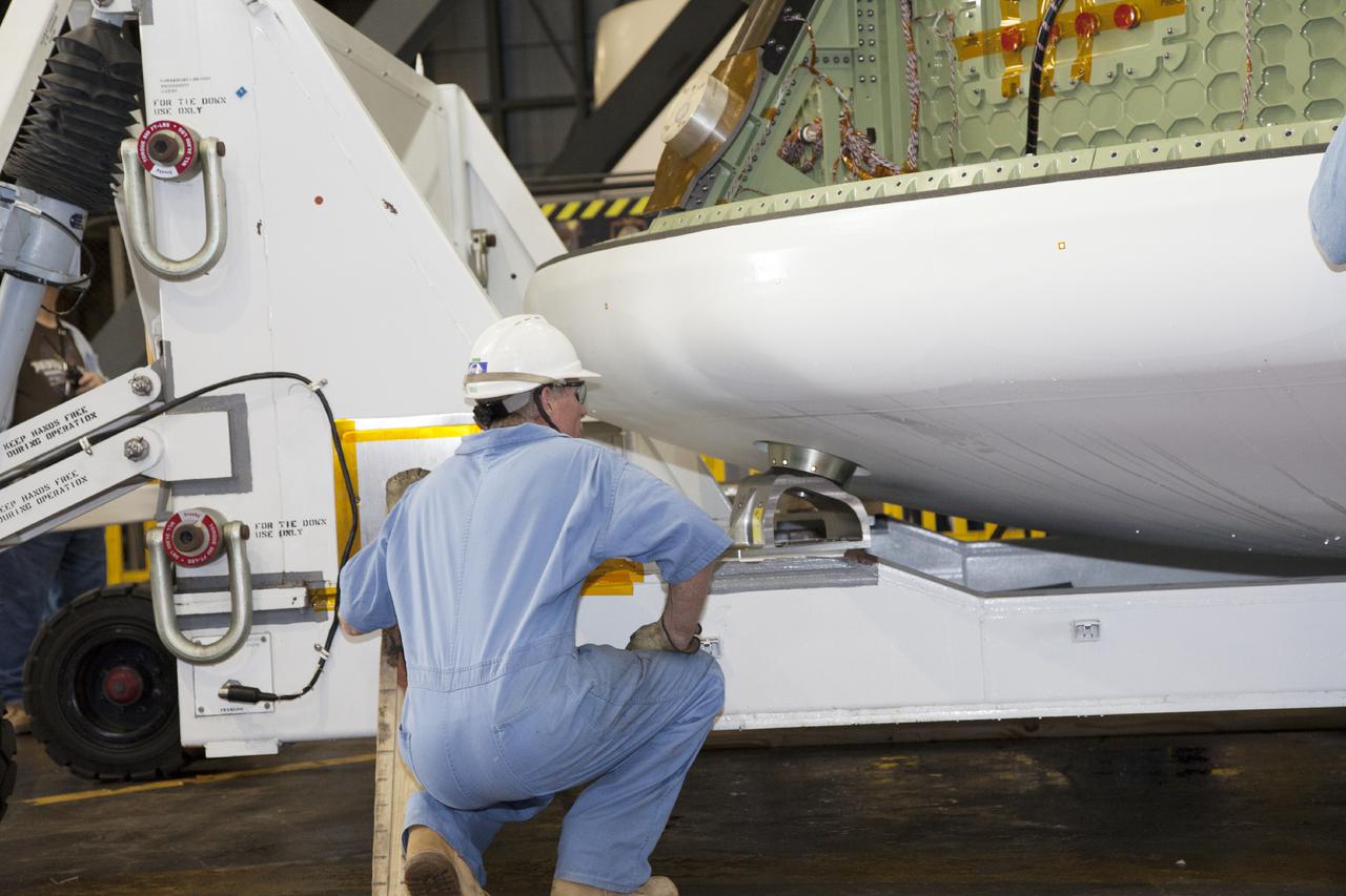 CAPE CANAVERAL, Fla. – Inside the Vehicle Assembly Building at NASA’s Kennedy Space Center in Florida, a technician monitors the progress as a bridge crane attached to the Orion ground test vehicle begins to lift it away from the heat shield. The ground test vehicle is being prepared for its move to Langley Research Center in Hampton, Va., for a water test. The test vehicle is being used by the Ground Systems Development and Operations Program for path finding operations, including simulated manufacturing, assembly and stacking procedures. Orion is the exploration spacecraft designed to carry astronauts to destinations not yet explored by humans. It will have emergency abort capability, sustain the crew during space travel and provide safe re-entry from deep space return velocities. The first unpiloted test flight of Orion is scheduled to launch in 2014 atop a Delta IV Heavy rocket and in 2017 on NASA’s Space Launch System rocket. For more information, visit www.nasa.gov_orion. Photo credit: Daniel Casper