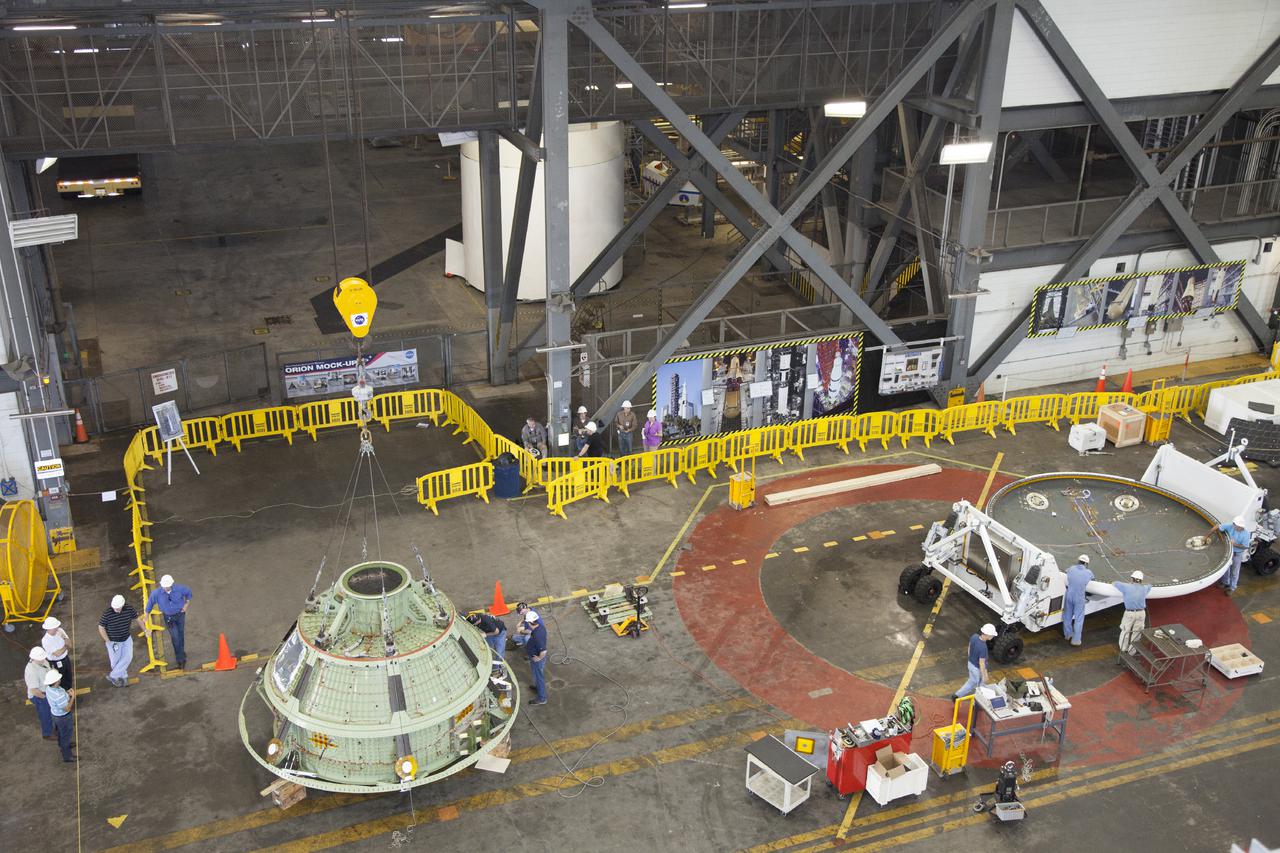 CAPE CANAVERAL, Fla. – Inside the Vehicle Assembly Building at NASA’s Kennedy Space Center in Florida, a bridge crane attached to the Orion ground test vehicle has lifted it away from the heat shield and lowered it onto a platform. The ground test vehicle is being prepared for its move to Langley Research Center in Hampton, Va., for a water test. The test vehicle is being used by the Ground Systems Development and Operations Program for path finding operations, including simulated manufacturing, assembly and stacking procedures. Orion is the exploration spacecraft designed to carry astronauts to destinations not yet explored by humans. It will have emergency abort capability, sustain the crew during space travel and provide safe re-entry from deep space return velocities. The first unpiloted test flight of Orion is scheduled to launch in 2014 atop a Delta IV Heavy rocket and in 2017 on NASA’s Space Launch System rocket. For more information, visit www.nasa.gov_orion. Photo credit: Daniel Casper