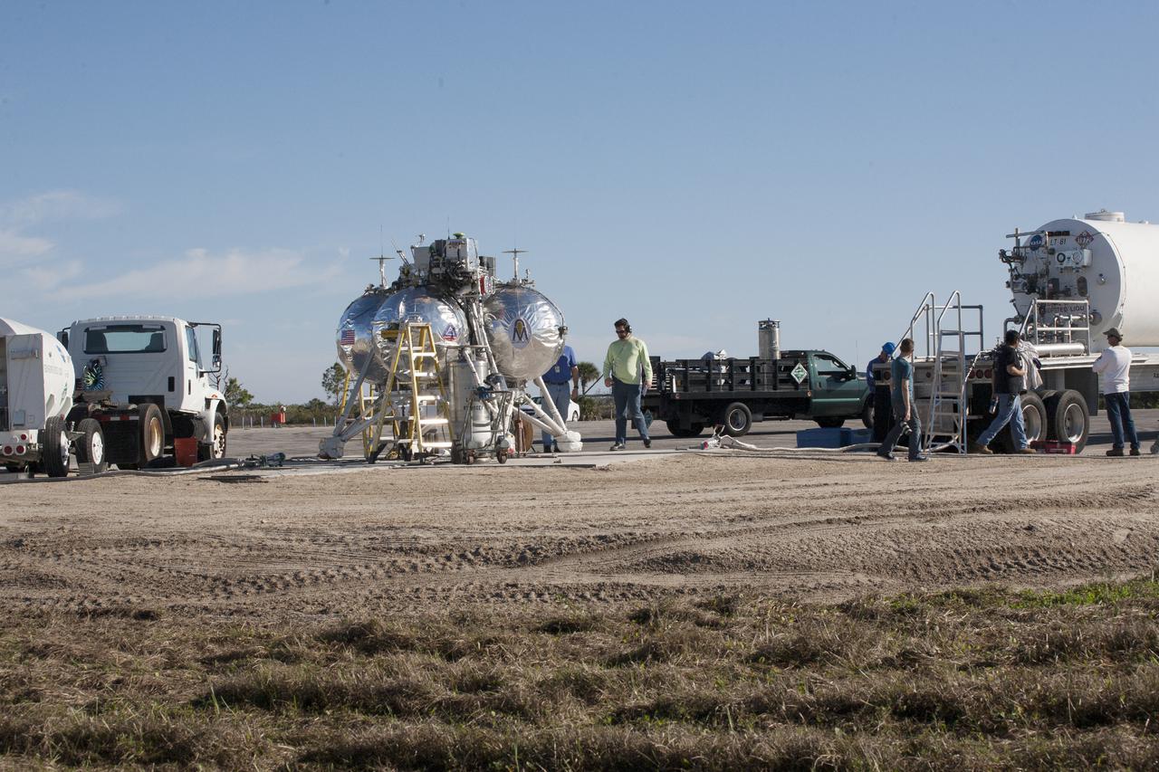 CAPE CANAVERAL, Fla. – The Project Morpheus prototype lander is being prepared for its fifth free flight test at the north end of the Shuttle Landing Facility at NASA’s Kennedy Space Center in Florida. The 74-second test began around 1 p.m. EST with the Morpheus lander launching from the ground over a flame trench and ascending 467 feet, more than 160 feet higher than its last test. Morpheus flew forward, covering 637 feet in 30 second before descending and landing on target on a dedicated pad inside the autonomous landing and hazard avoidance technology, or ALHAT, hazard field. Project Morpheus tests NASA’s ALHAT and an engine that runs on liquid oxygen and methane, or green propellants, into a fully-operational lander that could deliver cargo to other planetary surfaces.  The landing facility provides the lander with the kind of field necessary for realistic testing, complete with rocks, craters and hazards to avoid. Morpheus’ ALHAT payload will allow it to navigate to clear landing sites amidst rocks, craters and other hazards during its descent. Project Morpheus is being managed under the Advanced Exploration Systems, or AES, Division in NASA’s Human Exploration and Operations Mission Directorate. The efforts in AES pioneer new approaches for rapidly developing prototype systems, demonstrating key capabilities and validating operational concepts for future human missions beyond Earth orbit. For more information, visit http:__morpheuslander.jsc.nasa.gov. Photo credit: NASA_Kim Shiflett