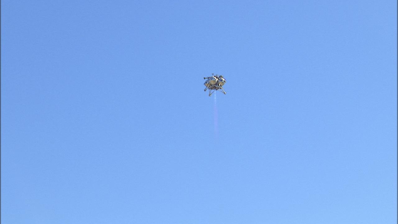 CAPE CANAVERAL, Fla. – The fifth free flight of the Project Morpheus prototype lander was conducted at the north end of the Shuttle Landing Facility at NASA’s Kennedy Space Center in Florida. The 74-second test began at about 1 p.m. EST with the Morpheus lander launching from the ground over a flame trench and ascending about to 476 feet, more than 160 feet higher than its last test. The lander flew forward, covering 637 feet in 30 seconds before descending and landing on target on a dedicated landing pad inside the autonomous landing and hazard avoidance technology, or ALHAT, hazard field. Project Morpheus tests NASA’s ALHAT and an engine that runs on liquid oxygen and methane, or green propellants, into a fully-operational lander that could deliver cargo to other planetary surfaces.  The landing facility provides the lander with the kind of field necessary for realistic testing, complete with rocks, craters and hazards to avoid. Morpheus’ ALHAT payload allows it to navigate to clear landing sites amidst rocks, craters and other hazards during its descent. Project Morpheus is being managed under the Advanced Exploration Systems, or AES, Division in NASA’s Human Exploration and Operations Mission Directorate. The efforts in AES pioneer new approaches for rapidly developing prototype systems, demonstrating key capabilities and validating operational concepts for future human missions beyond Earth orbit. For more information on Project Morpheus, visit http:__www.nasa.gov_centers_johnson_exploration_morpheus.  Photo credit: NASA_Frankie Martin