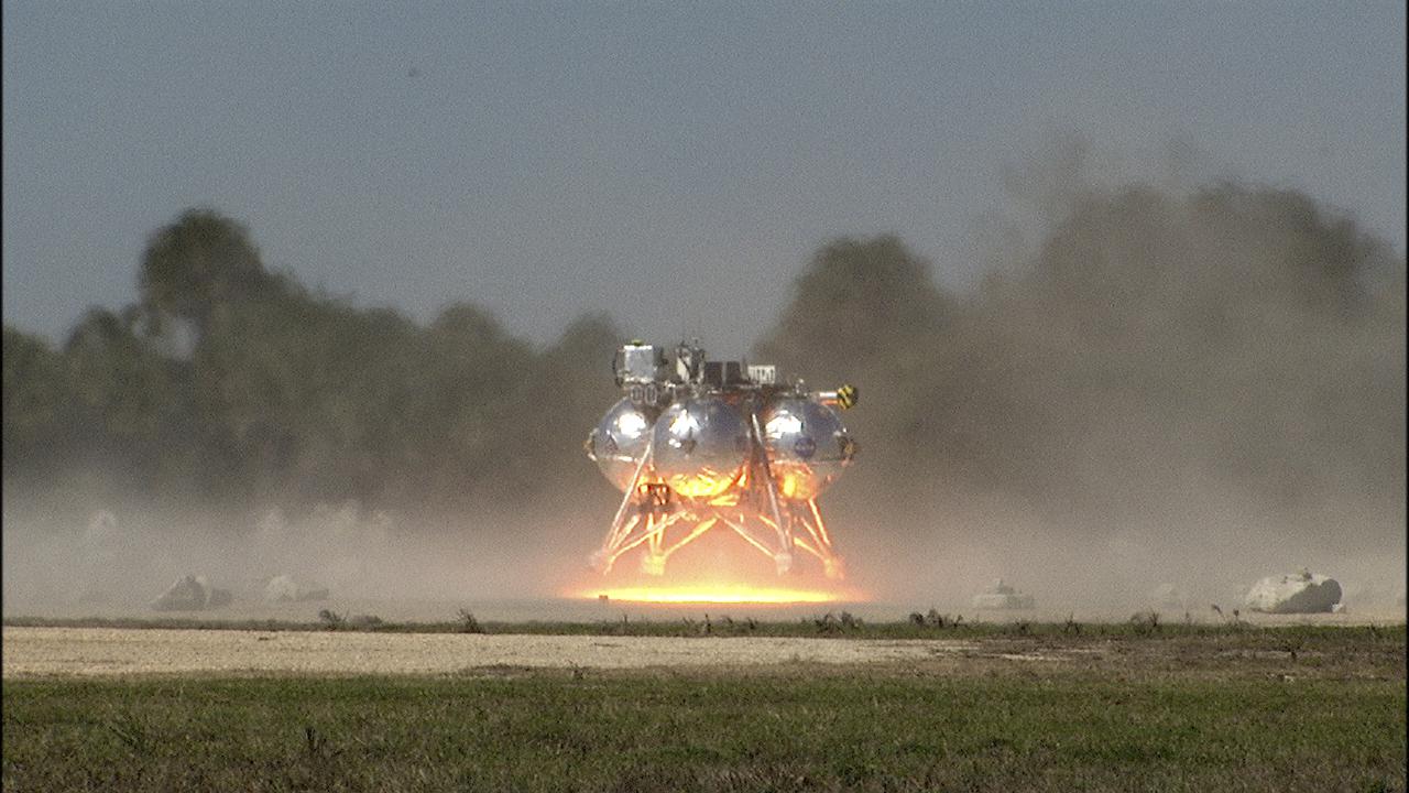 CAPE CANAVERAL, Fla. – The fifth free flight of the Project Morpheus prototype lander was conducted at the north end of the Shuttle Landing Facility at NASA’s Kennedy Space Center in Florida. The 74-second test began at about 1 p.m. EST with the Morpheus lander launching from the ground over a flame trench and ascending about to 476 feet, more than 160 feet higher than its last test. The lander flew forward, covering 637 feet in 30 seconds before descending and landing on target on a dedicated landing pad inside the autonomous landing and hazard avoidance technology, or ALHAT, hazard field. Project Morpheus tests NASA’s ALHAT and an engine that runs on liquid oxygen and methane, or green propellants, into a fully-operational lander that could deliver cargo to other planetary surfaces.  The landing facility provides the lander with the kind of field necessary for realistic testing, complete with rocks, craters and hazards to avoid. Morpheus’ ALHAT payload allows it to navigate to clear landing sites amidst rocks, craters and other hazards during its descent. Project Morpheus is being managed under the Advanced Exploration Systems, or AES, Division in NASA’s Human Exploration and Operations Mission Directorate. The efforts in AES pioneer new approaches for rapidly developing prototype systems, demonstrating key capabilities and validating operational concepts for future human missions beyond Earth orbit. For more information on Project Morpheus, visit http:__www.nasa.gov_centers_johnson_exploration_morpheus.  Photo credit: NASA_Frankie Martin