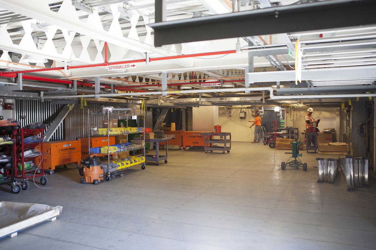 CAPE CANAVERAL, Fla. – Modifications continue on the Mobile Launcher, or ML, at the Mobile Launcher Park Site at NASA’s Kennedy Space Center in Florida. Construction workers check cables and wiring beneath the surface of the ML.  In 2013, the agency awarded a contract to J.P. Donovan Construction Inc. of Rockledge, Fla., to modify the ML, which is one of the key elements of ground support equipment that is being upgraded by the Ground Systems Development and Operations Program office at Kennedy. The ML will carry the SLS rocket and Orion spacecraft to Launch Pad 39B for its first mission, Exploration Mission 1, in 2017. Photo credit: NASA_Dimitri Gerondidakis