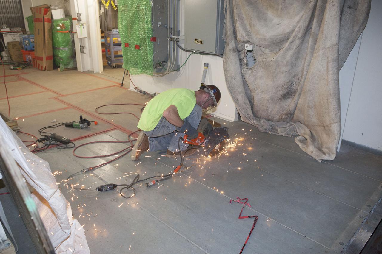 CAPE CANAVERAL, Fla. – Modifications continue on the Mobile Launcher, or ML, at the Mobile Launcher Park Site at NASA’s Kennedy Space Center in Florida. A construction worker uses a saw to cut through a portion of the flooring beneath the surface of the ML.  In 2013, the agency awarded a contract to J.P. Donovan Construction Inc. of Rockledge, Fla., to modify the ML, which is one of the key elements of ground support equipment that is being upgraded by the Ground Systems Development and Operations Program office at Kennedy. The ML will carry the SLS rocket and Orion spacecraft to Launch Pad 39B for its first mission, Exploration Mission 1, in 2017. Photo credit: NASA_Dimitri Gerondidakis
