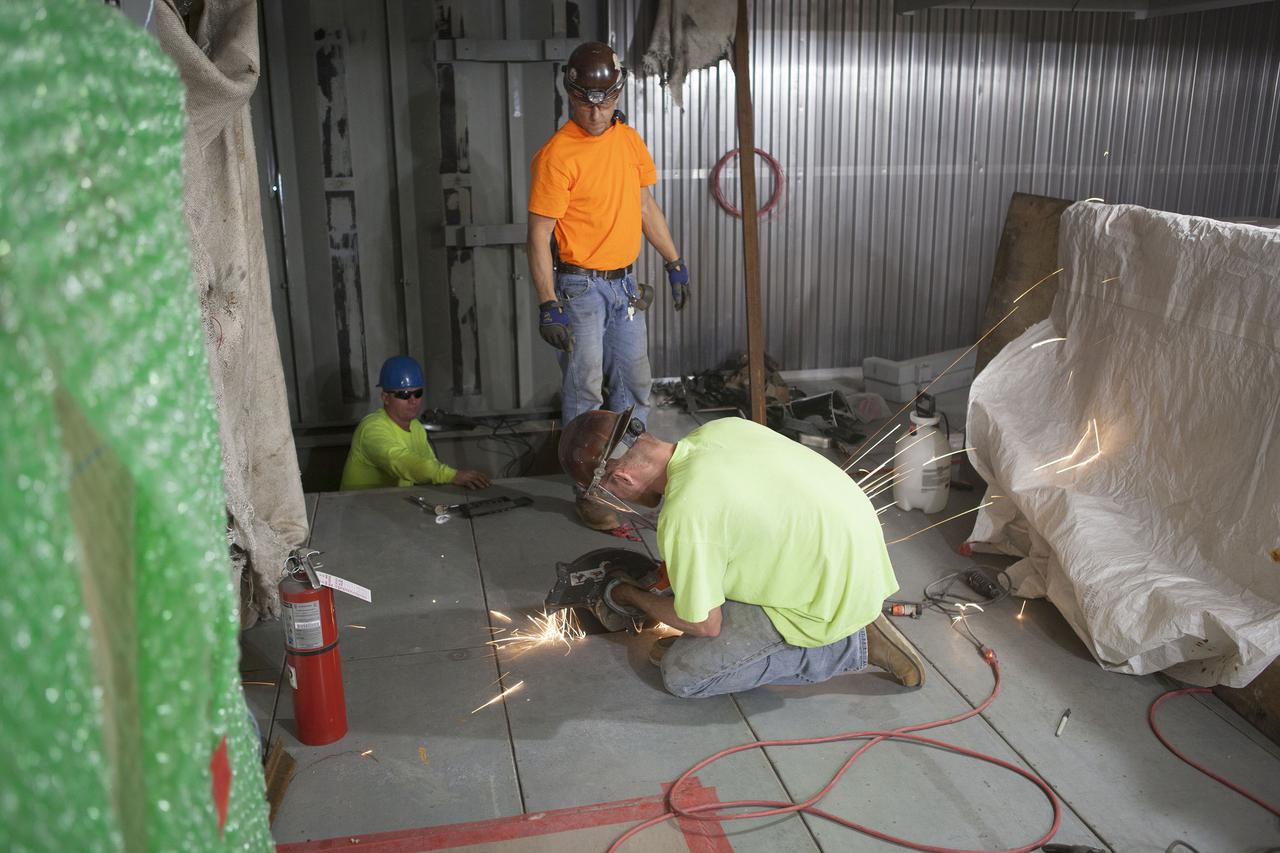 CAPE CANAVERAL, Fla. – Modifications continue on the Mobile Launcher, or ML, at the Mobile Launcher Park Site at NASA’s Kennedy Space Center in Florida. A construction worker uses a saw to cut through a portion of the flooring beneath the surface of the ML.  In 2013, the agency awarded a contract to J.P. Donovan Construction Inc. of Rockledge, Fla., to modify the ML, which is one of the key elements of ground support equipment that is being upgraded by the Ground Systems Development and Operations Program office at Kennedy. The ML will carry the SLS rocket and Orion spacecraft to Launch Pad 39B for its first mission, Exploration Mission 1, in 2017. Photo credit: NASA_Dimitri Gerondidakis