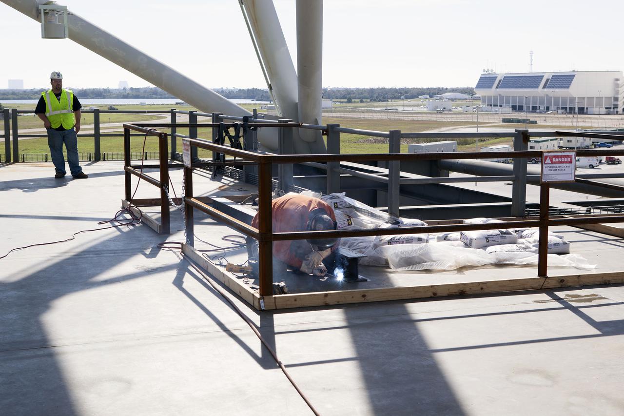 CAPE CANAVERAL, Fla. – Modifications continue on the Mobile Launcher, or ML, at the Mobile Launcher Park Site at NASA’s Kennedy Space Center in Florida. A construction worker welds a metal beam on the surface of the ML.  In 2013, the agency awarded a contract to J.P. Donovan Construction Inc. of Rockledge, Fla., to modify the ML, which is one of the key elements of ground support equipment that is being upgraded by the Ground Systems Development and Operations Program office at Kennedy. The ML will carry the SLS rocket and Orion spacecraft to Launch Pad 39B for its first mission, Exploration Mission 1, in 2017. Photo credit: NASA_Dimitri Gerondidakis