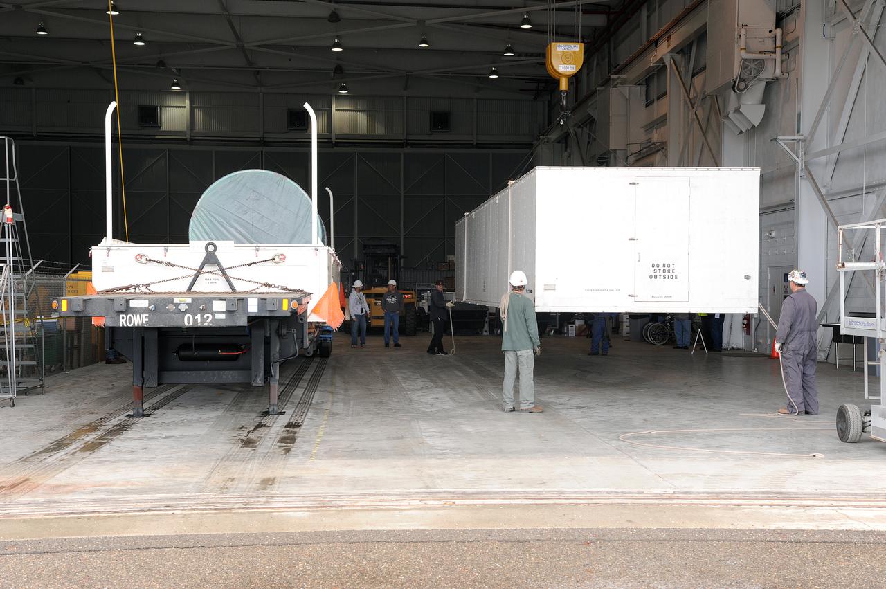VANDENBERG AIR FORCE BASE, Calif. – Workers remove the cover of the transportation trailer protecting the interstage adapter, or ISA, for NASA's Orbiting Carbon Observatory-2 mission, or OCO-2, in the high bay of the Building 836 hangar on Vandenberg Air Force Base in California.  OCO-2 is scheduled to launch aboard a United Launch Alliance Delta II rocket from Space Launch Complex 2 in July. The ISA is the interface between the Delta II first and second stages. The second stage engine fits within the ISA.  OCO-2 will collect precise global measurements of carbon dioxide in the Earth's atmosphere and provide scientists with a better idea of the chemical compound's impacts on climate change. Scientists will analyze this data to improve our understanding of the natural processes and human activities that regulate the abundance and distribution of this important atmospheric gas. To learn more about OCO-2, visit http:__oco.jpl.nasa.gov.  Photo credit: NASA_Jeremy Moore, 30th Space Wing, VAFB