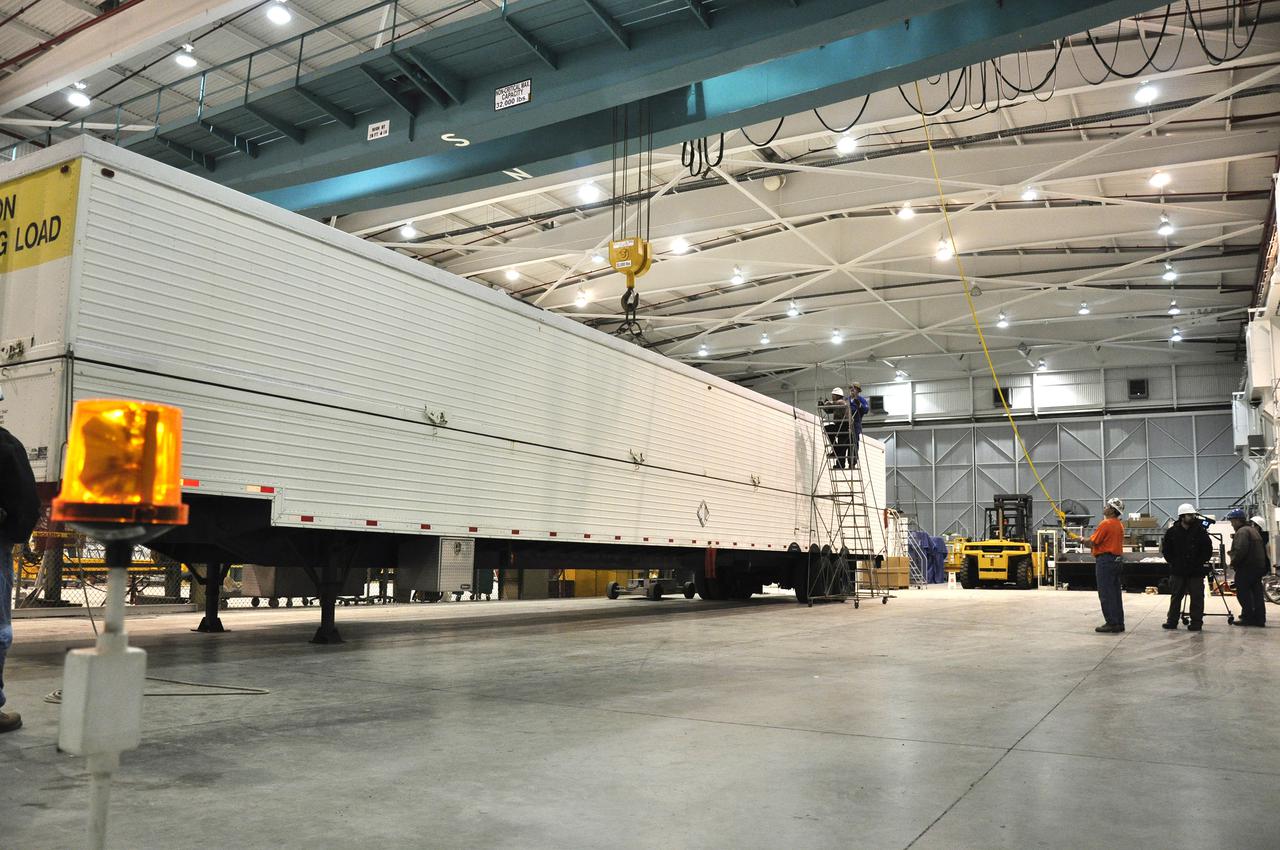VANDENBERG AIR FORCE BASE, Calif. – Workers prepare to remove the cover of the transportation trailer protecting the second stage for NASA's Orbiting Carbon Observatory-2 mission, or OCO-2, in the high bay of the Building 836 hangar on Vandenberg Air Force Base in California.  OCO-2 is scheduled to launch aboard a United Launch Alliance Delta II rocket from Space Launch Complex 2 in July. The rocket's second stage will insert OCO-2 into a polar Earth orbit.  OCO-2 will collect precise global measurements of carbon dioxide in the Earth's atmosphere and provide scientists with a better idea of the chemical compound's impacts on climate change. Scientists will analyze this data to improve our understanding of the natural processes and human activities that regulate the abundance and distribution of this important atmospheric gas. To learn more about OCO-2, visit http:__oco.jpl.nasa.gov. Photo credit: NASA_Randy Beaudoin