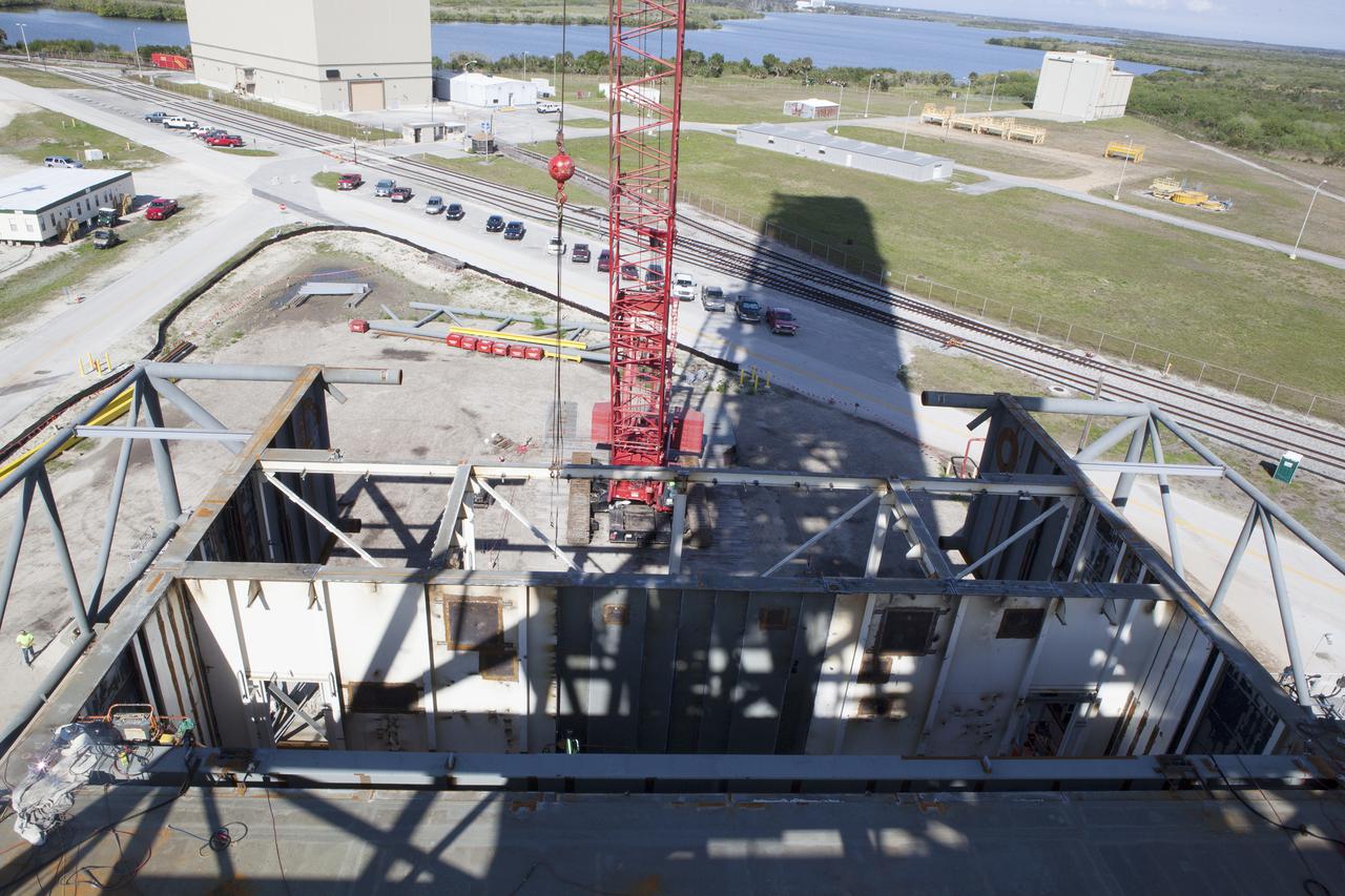 CAPE CANAVERAL, Fla. – Modifications continue on the Mobile Launcher, or ML, at the Mobile Launcher Park Site at NASA’s Kennedy Space Center in Florida. A view from above shows work in progress on the surface of the ML.  In 2013, the agency awarded a contract to J.P. Donovan Construction Inc. of Rockledge, Fla., to modify the ML, which is one of the key elements of ground support equipment that is being upgraded by the Ground Systems Development and Operations Program office at Kennedy. The ML will carry the SLS rocket and Orion spacecraft to Launch Pad 39B for its first mission, Exploration Mission 1, in 2017. Photo credit: NASA_Dimitri Gerondidakis