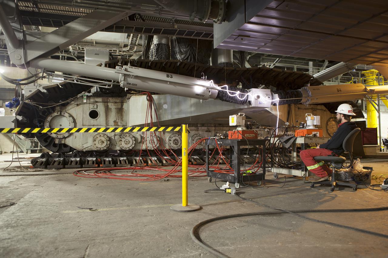 CAPE CANAVERAL, Fla. – Inside the Vehicle Assembly Building at NASA’s Kennedy Space Center in Florida, a technician monitors the progress as the B and D truck sections of crawler-transporter 2, or CT-2, are raised up to prepare for installation of new roller bearing assemblies.   Work continues in high bay 2 to upgrade CT-2. The modifications are designed to ensure CT-2’s ability to transport launch vehicles currently in development, such as the agency’s Space Launch System, to the launch pad. The Ground Systems Development and Operations Program office at Kennedy is overseeing the upgrades. For more than 45 years the crawler-transporters were used to transport the mobile launcher platform and the Apollo-Saturn V rockets and, later, space shuttles to Launch Pads 39A and B. For more information, visit: http:__www.nasa.gov_exploration_systems_ground_crawler-transporter. Photo credit: NASA_Dimitri Gerondidakis