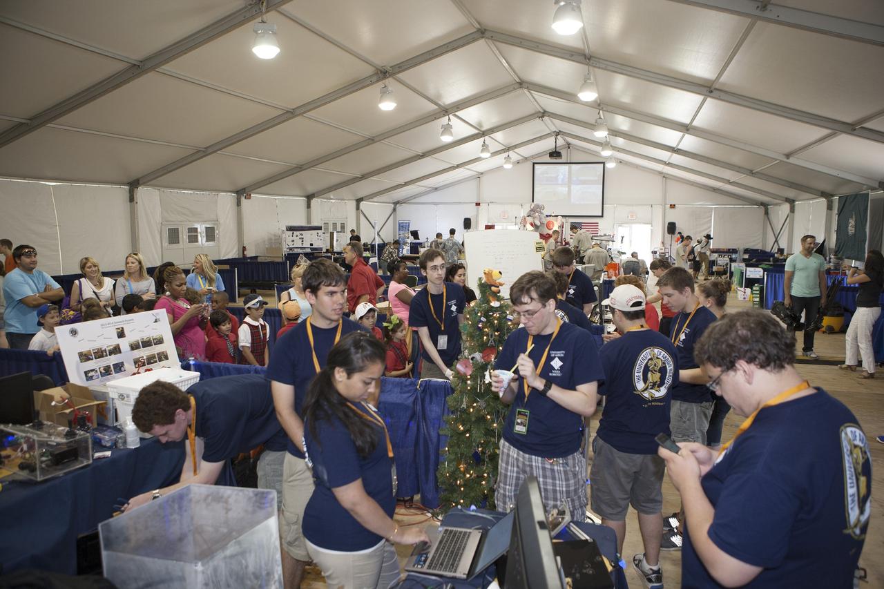 CAPE CANAVERAL, Fla. -- Team members from the University of Akron in Ohio take a break before their final mining run on the final day of NASA's 2014 Robotic Mining Competition at the Kennedy Space Center Visitor Complex in Florida. More than 35 teams from colleges and universities around the U.S. designed and built remote-controlled robots for the mining competition. The competition is a NASA Human Exploration and Operations Mission Directorate project designed to engage and retain students in science, technology, engineering and mathematics, or STEM, fields by expanding opportunities for student research and design. Teams use their remote-controlled robotics to maneuver and dig in a supersized sandbox filled with a crushed material that has characteristics similar to Martian soil. The objective of the challenge is to see which team’s robot can collect and move the most regolith within a specified amount of time. For more information, visit www.nasa.gov/nasarmc. Photo credit: NASA/Kim Shiflett