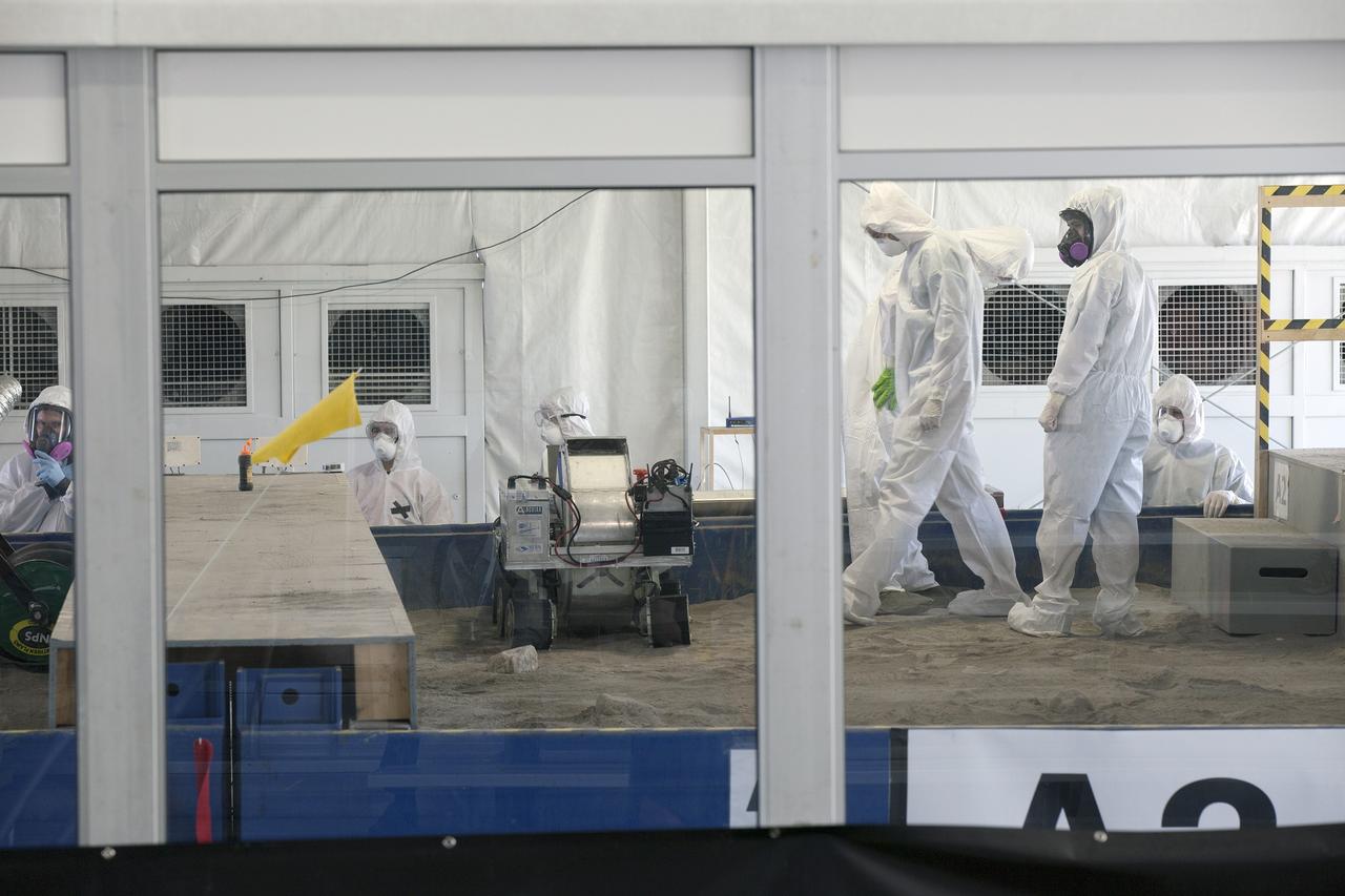CAPE CANAVERAL, Fla. -- Team members prepare their robot to dig in simulated Martian soil in the Caterpillar Mining Arena on the final day of NASA's 2014 Robotic Mining Competition at the Kennedy Space Center Visitor Complex in Florida. More than 35 teams from colleges and universities around the U.S. designed and built remote-controlled robots for the mining competition. The competition is a NASA Human Exploration and Operations Mission Directorate project designed to engage and retain students in science, technology, engineering and mathematics, or STEM, fields by expanding opportunities for student research and design. Teams use their remote-controlled robotics to maneuver and dig in a supersized sandbox filled with a crushed material that has characteristics similar to Martian soil. The objective of the challenge is to see which team’s robot can collect and move the most regolith within a specified amount of time. For more information, visit www.nasa.gov/nasarmc. Photo credit: NASA/Kim Shiflett