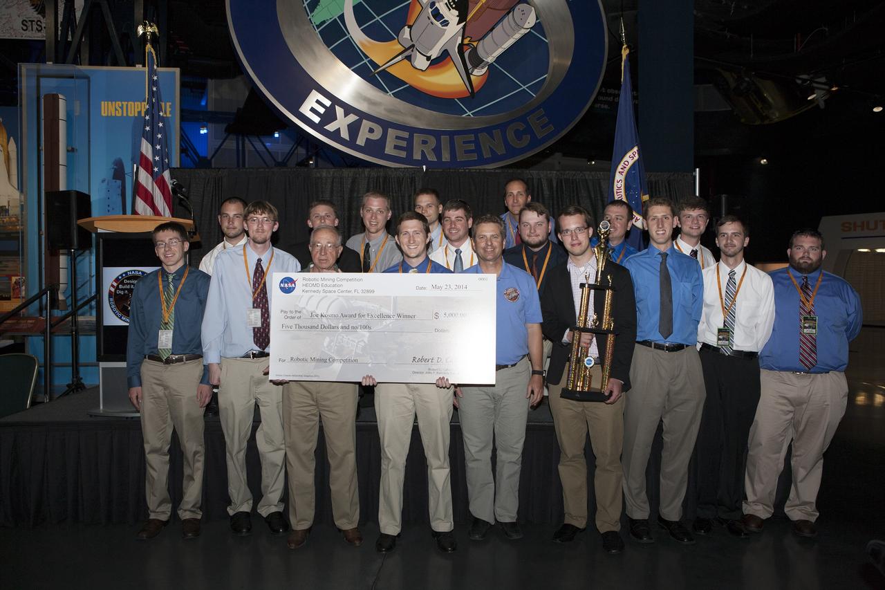CAPE CANAVERAL, Fla. -- The University of Alabama team Astrobotics in collaboration with Shelton State Community College received the highest award, the Joe Kosmo Award for Excellence, during NASA's 2014 Robotic Mining Competition awards ceremony inside the Space Shuttle Atlantis attraction at the Kennedy Space Center Visitor Complex in Florida. More than 35 teams from colleges and universities around the U.S. designed and built remote-controlled robots for the mining competition. The competition is a NASA Human Exploration and Operations Mission Directorate project designed to engage and retain students in science, technology, engineering and mathematics, or STEM, fields by expanding opportunities for student research and design. Teams use their remote-controlled robotics to maneuver and dig in a supersized sandbox filled with a crushed material that has characteristics similar to Martian soil. The objective of the challenge is to see which team’s robot can collect and move the most regolith within a specified amount of time. The competition includes on-site mining, writing a systems engineering paper, performing outreach projects for K-12 students, slide presentation and demonstrations, and team spirit. For more information, visit www.nasa.gov/nasarmc. Photo credit: NASA/Kim Shiflett