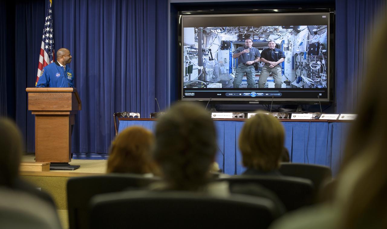 NASA associate administrator for education and former astronaut Leland Melvin, left, watches as astronauts, Rick Mastracchio, screen left, and Michael Hopkins, deliver a message from the International Space Station (ISS) to attendees of the annual White House State of Science, Technology, Engineering, and Math (SoSTEM) address, Wednesday, Jan. 29, 2014, in the South Court Auditorium in the Eisenhower Executive Office Building on the White House complex in Washington. Photo Credit: (NASA/Bill Ingalls)