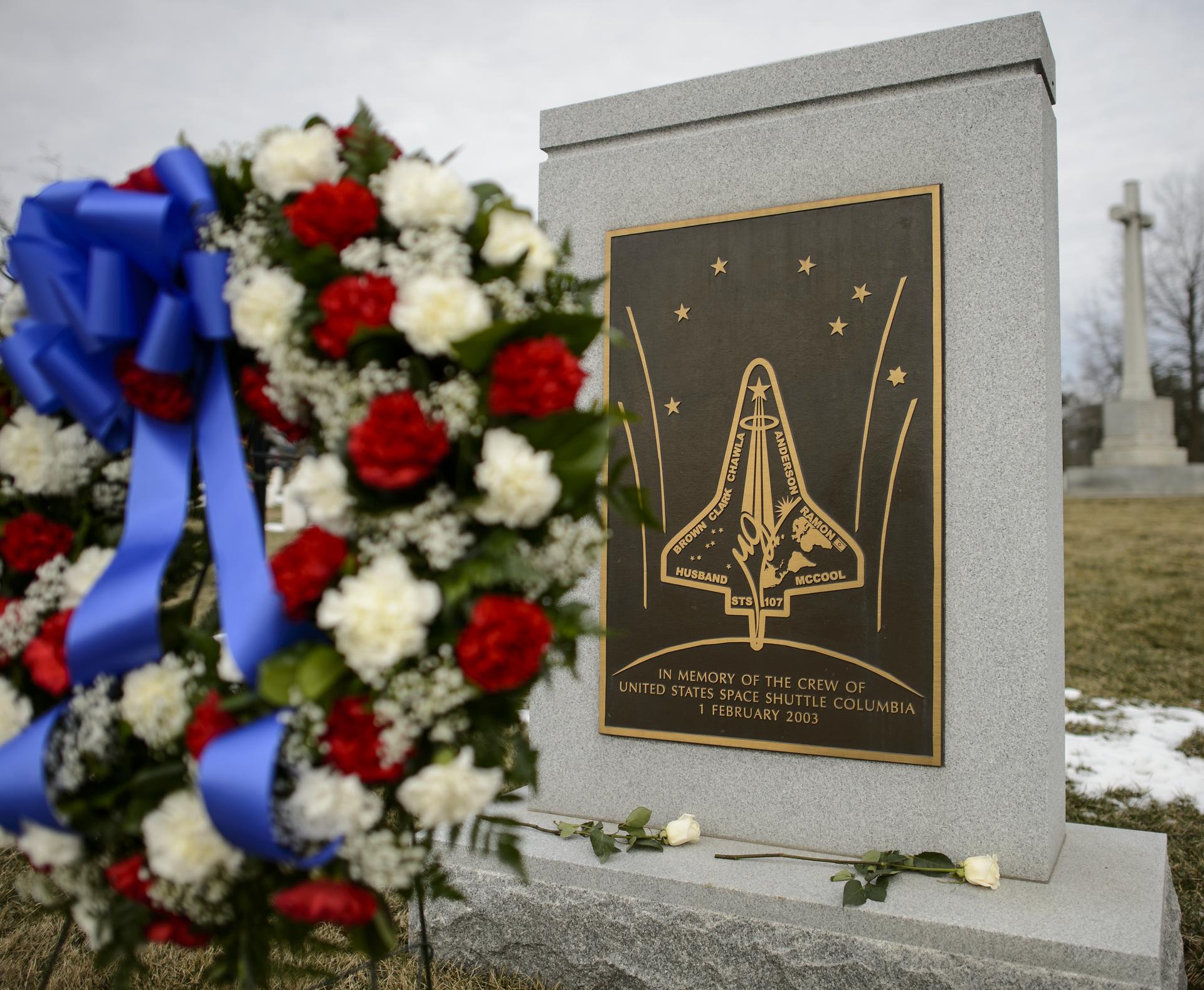 A monument at Arlington National Cemetery for Space Shuttle Columbia with a wreath placed next to it.