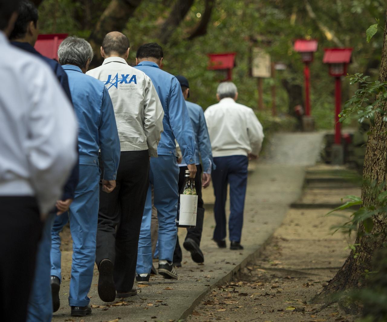 Japan Aerospace Exploration Agency (JAXA) team members walk with their offering of sake to the Houman Shrine, the third, and final, shrine in a traditional San-ja Mairi, or Three Shrine Pilgrimage, where the team prays for a successful launch, Tuesday, Feb. 25, 2014, Tanegashima Island, Japan. A Japanese H-IIA rocket carrying the NASA-JAXA, Global Precipitation Measurement (GPM) Core Observatory is planned for launch from the Tanegashima Space Center (TNSC) on Feb. 28, 2014. Once launched, the GPM spacecraft will collect information that unifies data from an international network of existing and future satellites to map global rainfall and snowfall every three hours.  Photo Credit: (NASA/Bill Ingalls)