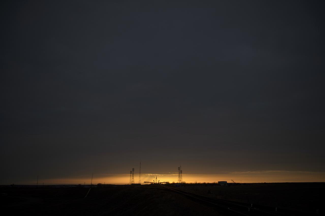 The sun rises behind the Soyuz launch pad shortly before the Soyuz TMA-12M spacecraft is rolled out by train to the launch pad at the Baikonur Cosmodrome, Kazakhstan, Sunday, March, 23, 2014.  Launch of the Soyuz rocket is scheduled for March 26 and will send Expedition 39 Soyuz Commander Alexander Skvortsov of the Russian Federal Space Agency, Roscosmos, Flight Engineer Steven Swanson of NASA, and Flight Engineer Oleg Artemyev of Roscosmos on a six-month mission aboard the International Space Station.Photo Credit (NASA/Joel Kowsky)