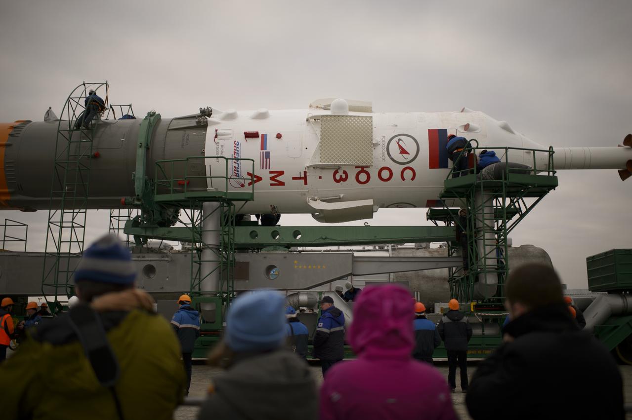 Workers prepare the Soyuz TMA-12M spacecraft to be raised into a vertical position after it was rolled out to the launch pad by train on Sunday, March 23, 2014, at the Baikonur Cosmodrome in Kazakhstan.  Launch of the Soyuz rocket is scheduled for March 26 and will send Expedition 39 Soyuz Commander Alexander Skvortsov of the Russian Federal Space Agency, Roscosmos, Flight Engineer Steven Swanson of NASA, and Flight Engineer Oleg Artemyev of Roscosmos on a six-month mission aboard the International Space Station.  Photo Credit: (NASA/Joel Kowsky)
