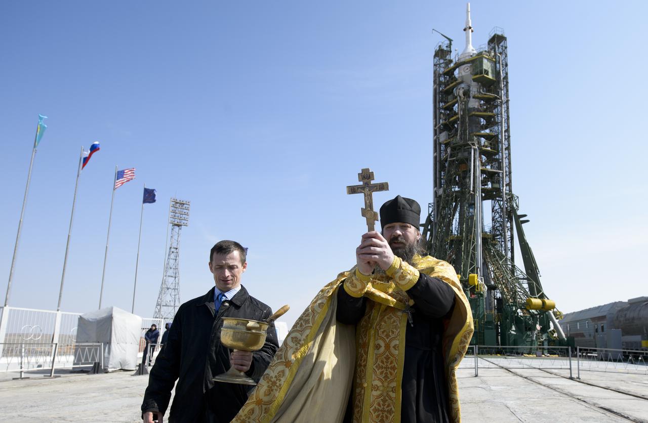An Orthodox priest blesses members of the media on the Soyouz launch pad at the Baikonur Cosmodrome launch pad on Monday, March 24, 2014 in Kazakhstan.  Launch of the Soyuz rocket is scheduled for March 26 and will send  Expedition 39 Soyuz Commander Alexander Skvortsov of the Russian Federal Space Agency, Flight Engineer Steve Swanson of NASA, and Flight Engineer Oleg Artemyev of Roscosmos on a six-month mission aboard the International Space Station.Photo Credit: (NASA/Joel Kowsky)