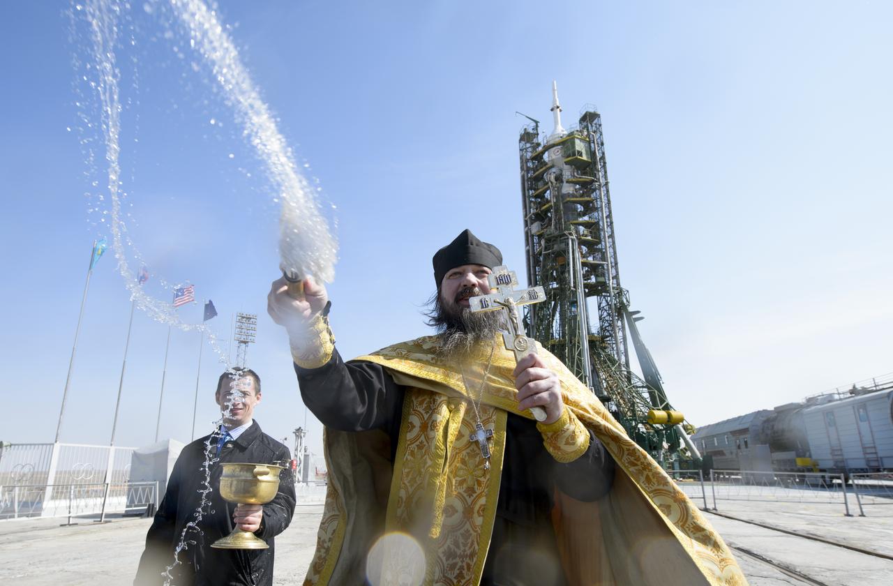 An Orthodox priest blesses members of the media on the Soyouz launch pad at the Baikonur Cosmodrome launch pad on Monday, March 24, 2014 in Kazakhstan.  Launch of the Soyuz rocket is scheduled for March 26 and will send  Expedition 39 Soyuz Commander Alexander Skvortsov of the Russian Federal Space Agency, Flight Engineer Steve Swanson of NASA, and Flight Engineer Oleg Artemyev of Roscosmos on a six-month mission aboard the International Space Station.Photo Credit: (NASA/Joel Kowsky)