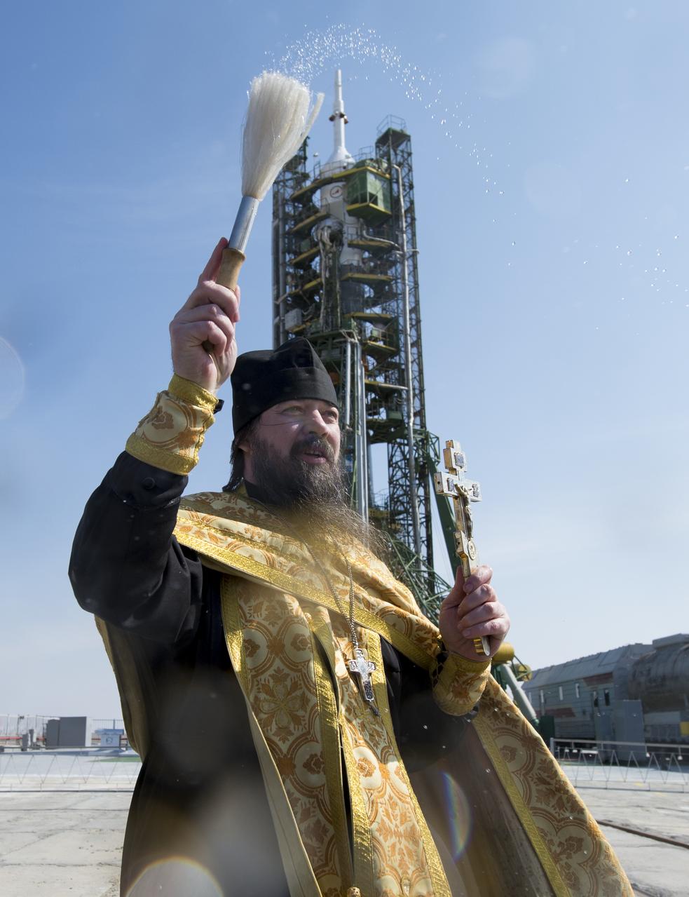 An Orthodox priest blesses members of the media on the Soyouz launch pad at the Baikonur Cosmodrome launch pad on Monday, March 24, 2014 in Kazakhstan.  Launch of the Soyuz rocket is scheduled for March 26 and will send  Expedition 39 Soyuz Commander Alexander Skvortsov of the Russian Federal Space Agency, Flight Engineer Steve Swanson of NASA, and Flight Engineer Oleg Artemyev of Roscosmos on a six-month mission aboard the International Space Station.Photo Credit: (NASA/Joel Kowsky)