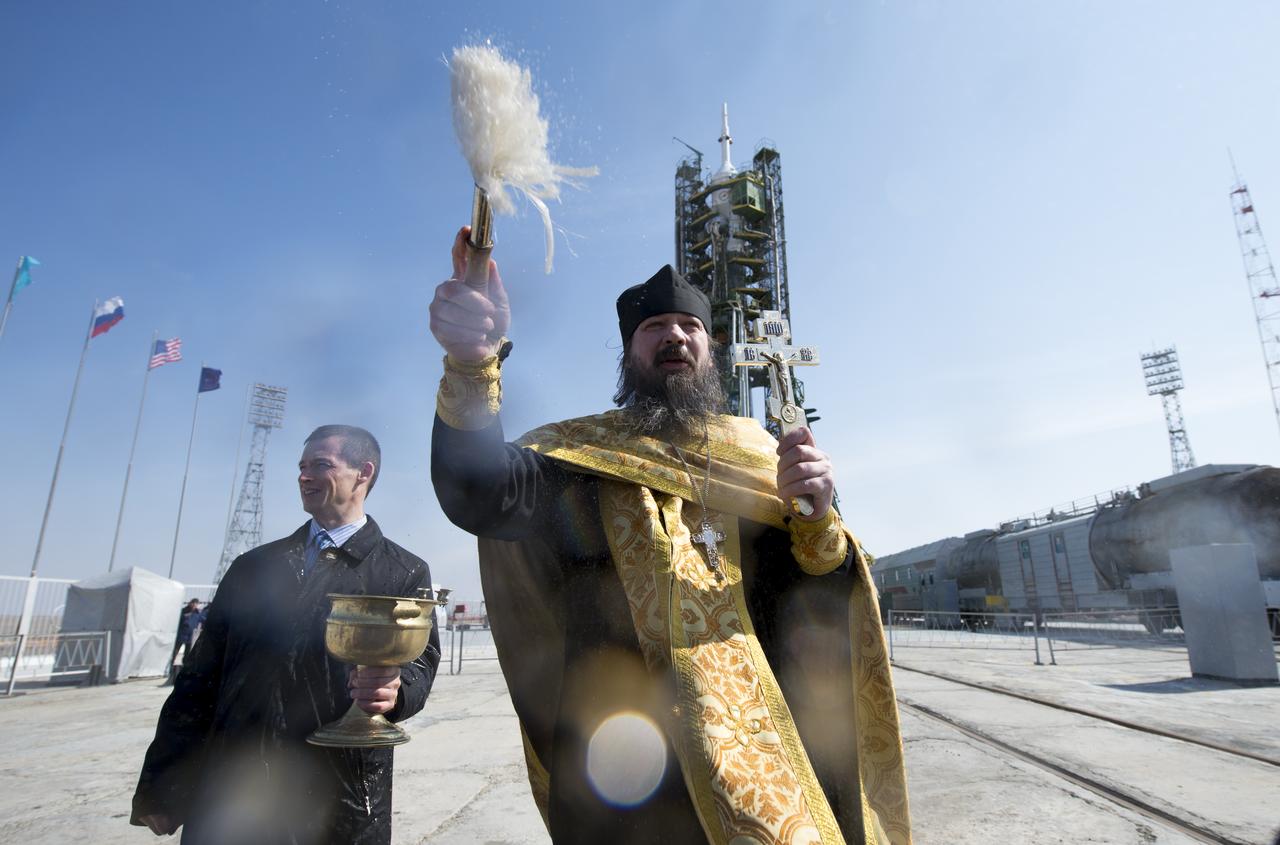 An Orthodox priest blesses members of the media on the Soyouz launch pad at the Baikonur Cosmodrome launch pad on Monday, March 24, 2014 in Kazakhstan.  Launch of the Soyuz rocket is scheduled for March 26 and will send  Expedition 39 Soyuz Commander Alexander Skvortsov of the Russian Federal Space Agency, Flight Engineer Steve Swanson of NASA, and Flight Engineer Oleg Artemyev of Roscosmos on a six-month mission aboard the International Space Station.Photo Credit: (NASA/Joel Kowsky)