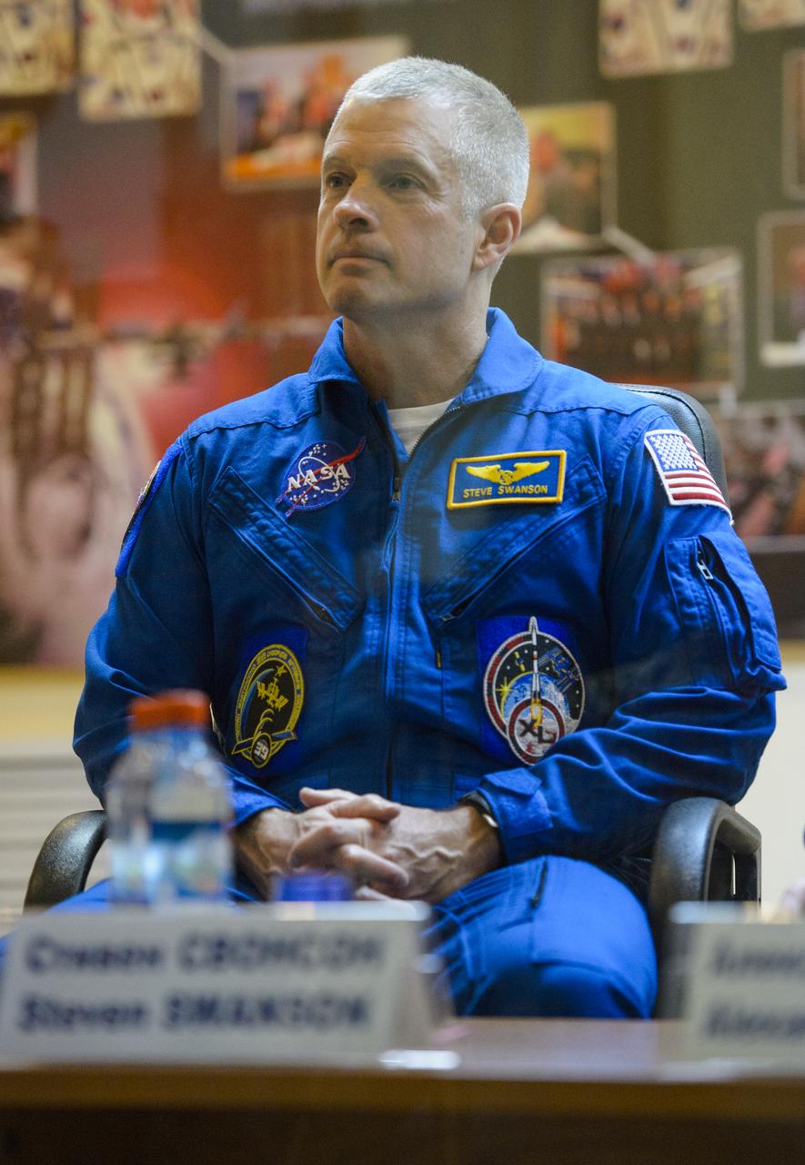 Expedition 39 flight engineer Steve Swanson of NASA is seen in quarantine, behind glass, during the final press conference be Monday, March 24, 2014, at the Cosmonaut Hotel in Baikonur, Kazakhstan. The mission to the International Space Station is set to launch March 26 from the Baikonur Cosmodrome. Photo Credit: (NASA/Joel Kowsky)
