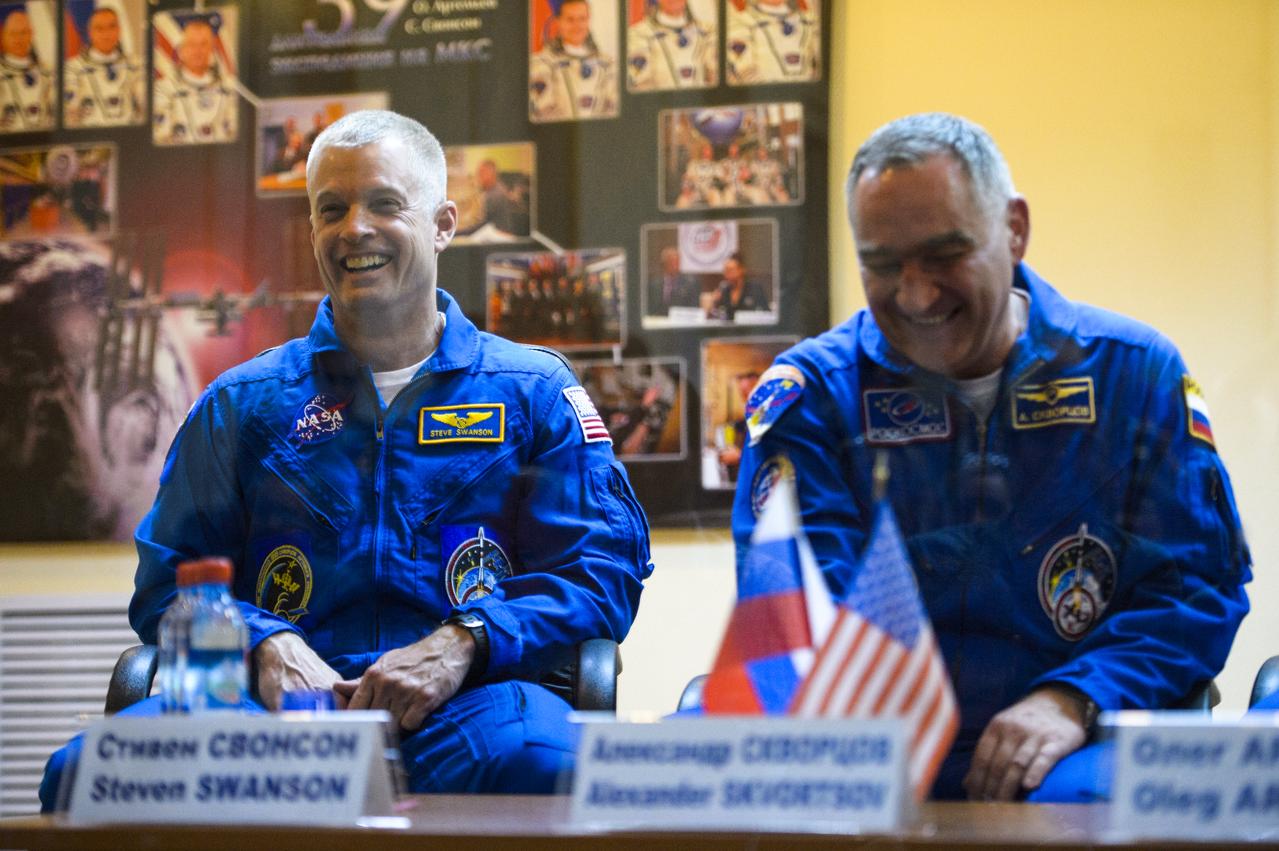 Expedition 39 flight engineer Steve Swanson of NASA and Soyuz commander Aleksander Skvortsov of the Russian Federal Space Agency, Roscosmos are seen in quarantine, behind glass, during the final press conference be Monday, March 24, 2014, at the Cosmonaut Hotel in Baikonur, Kazakhstan. The mission to the International Space Station is set to launch March 26 from the Baikonur Cosmodrome. Photo Credit: (NASA/Joel Kowsky)