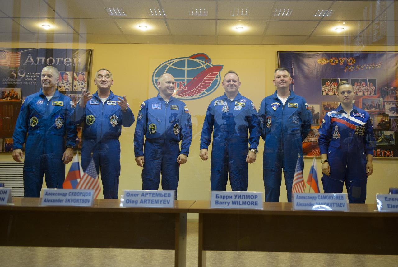 Expedition 39 primary crew flight engineer Steve Swanson of NASA, Soyuz commander Aleksander Skvortsov of the Russian Federal Space Agency, Roscosmos, flight engineer Oleg Artemyev of Roscosmos and Expedition 39 backup crew Barry Wilmore of NASA, Alexander Samokutyaev of Roscosmos, and Elena Serova of Roscosmos are seen in quarantine, behind glass, during the final press conference be Monday, March 24, 2014, at the Cosmonaut Hotel in Baikonur, Kazakhstan. The mission to the International Space Station is set to launch March 26 from the Baikonur Cosmodrome. Photo Credit: (NASA/Joel Kowsky)